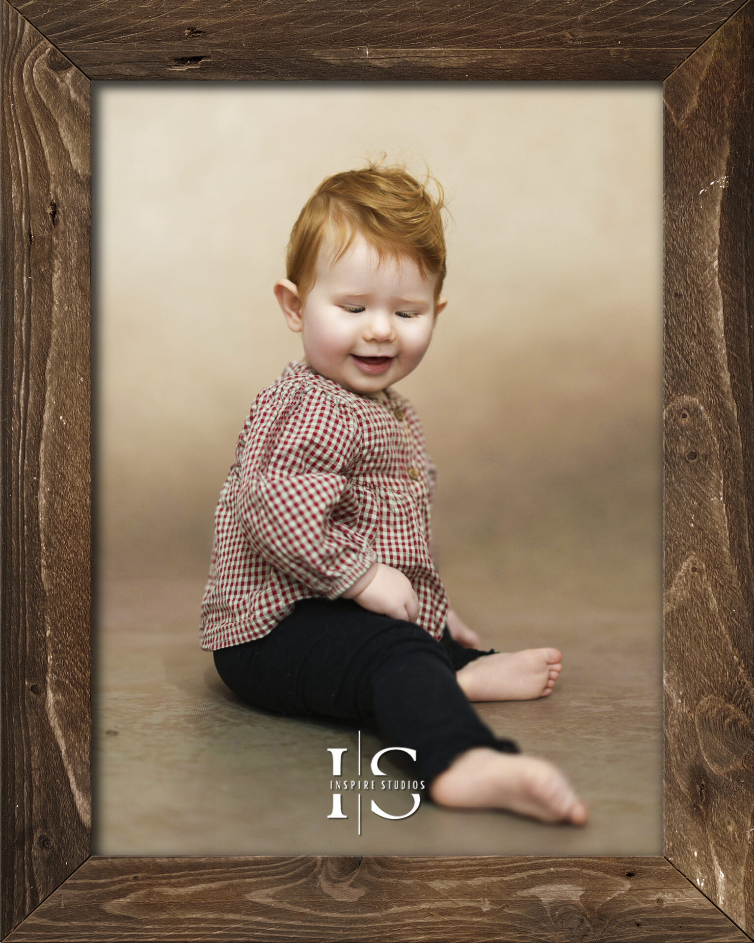 A smiling baby sitting on a soft blanket during a professional sitter photoshoot in a London studio.