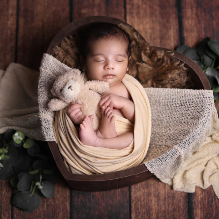 Newborn baby peacefully sleeping in a studio photo taken by a skilled female newborn photographer.