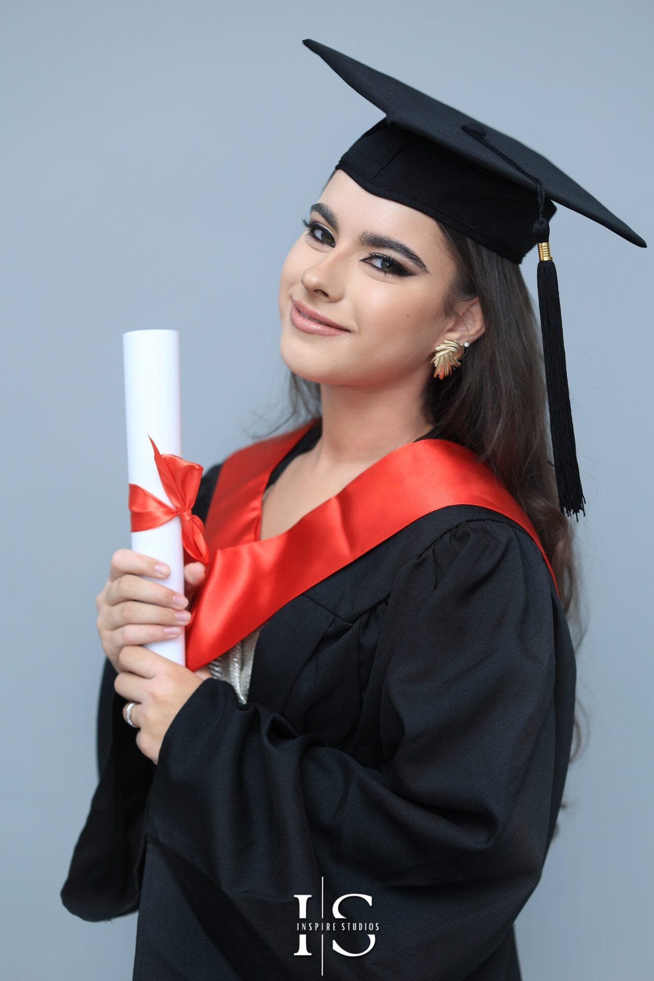 Graduate photographed against a soft light blue studio backdrop.