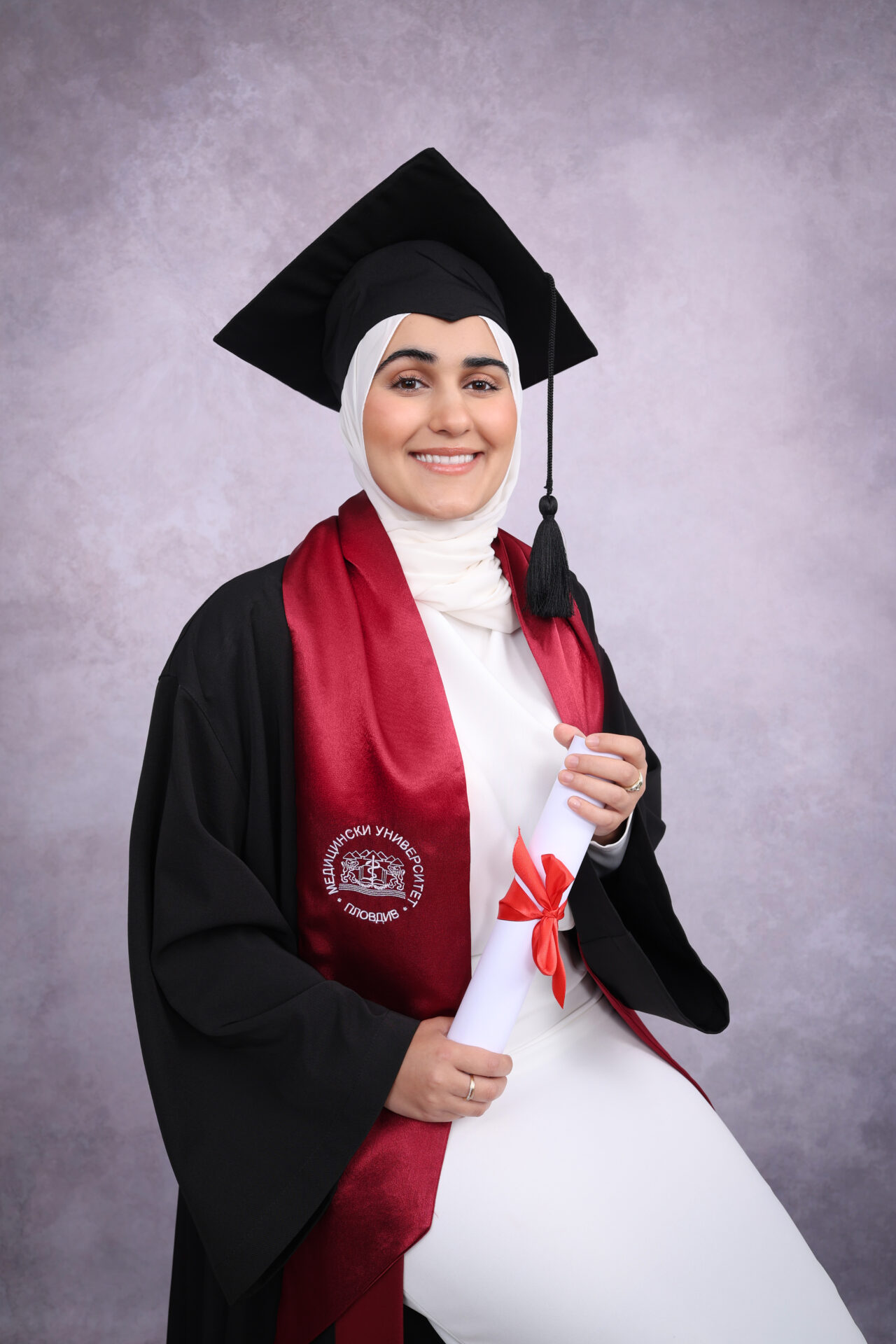 Female in Family Graduation Photography with gown, mortarboard and hat.