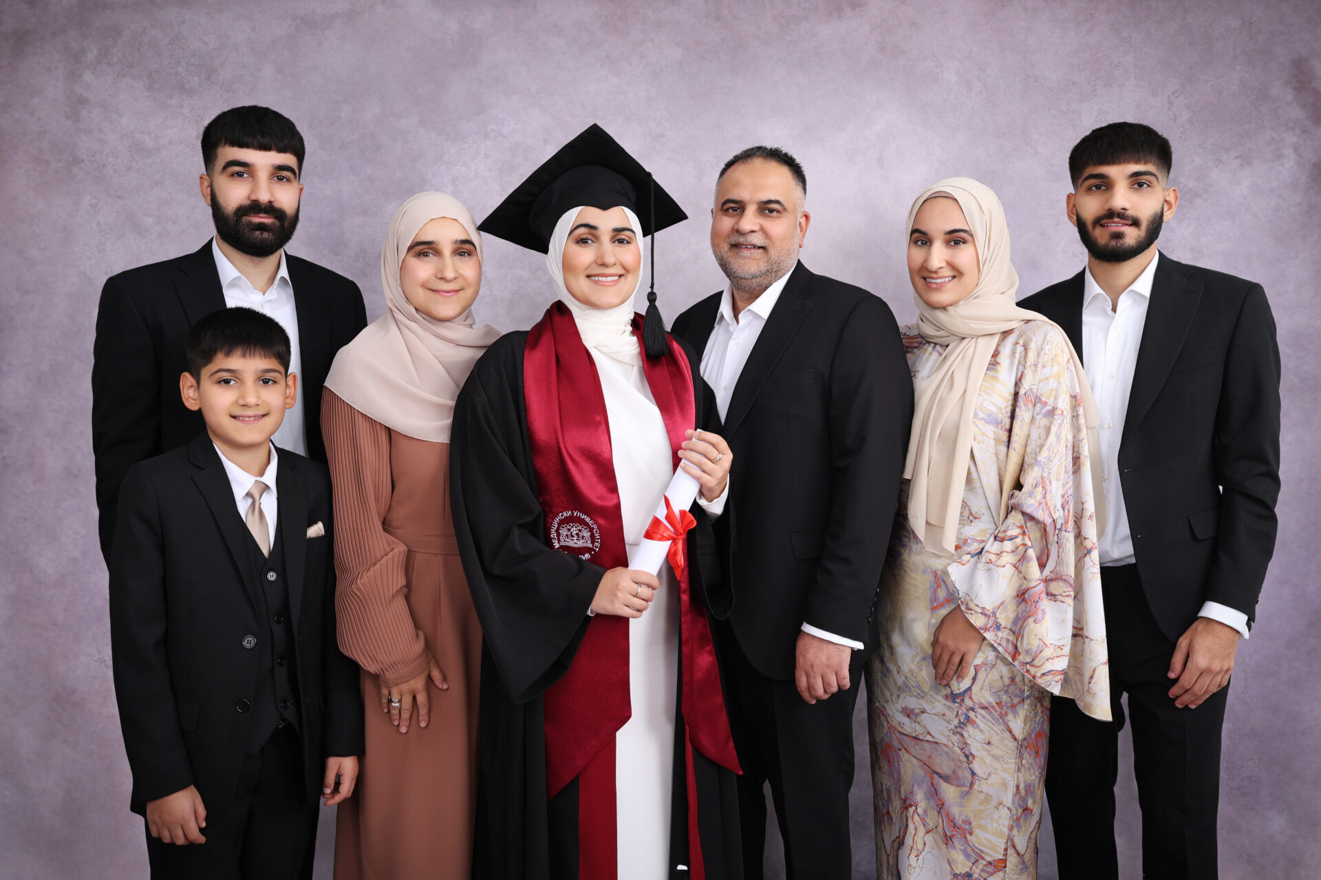 A nice Family Graduation Photography with gown, mortarboard and hat.