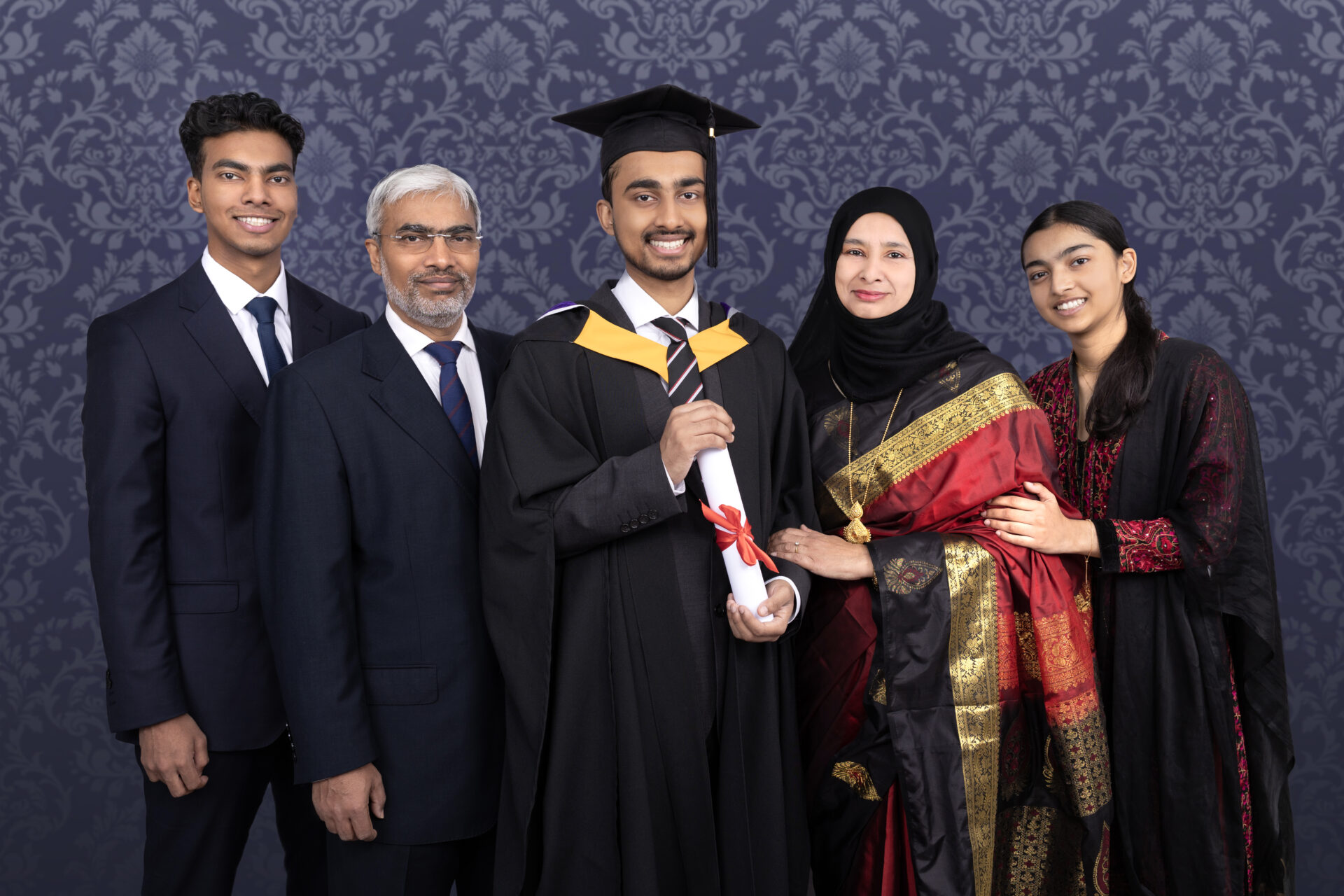 Family Graduation Photography with gown, mortarboard and hat.