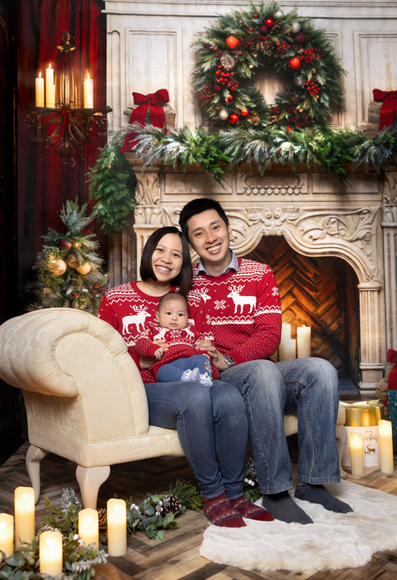 A cozy Christmas room with a classic fireplace, Christmas tree, and traditional red and green decorations.