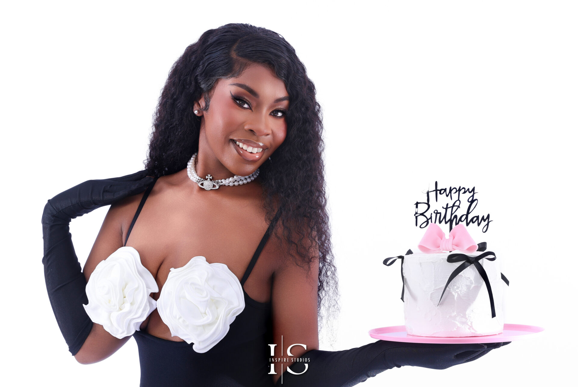 Woman posing with a cake and balloons during a custom birthday photoshoot.