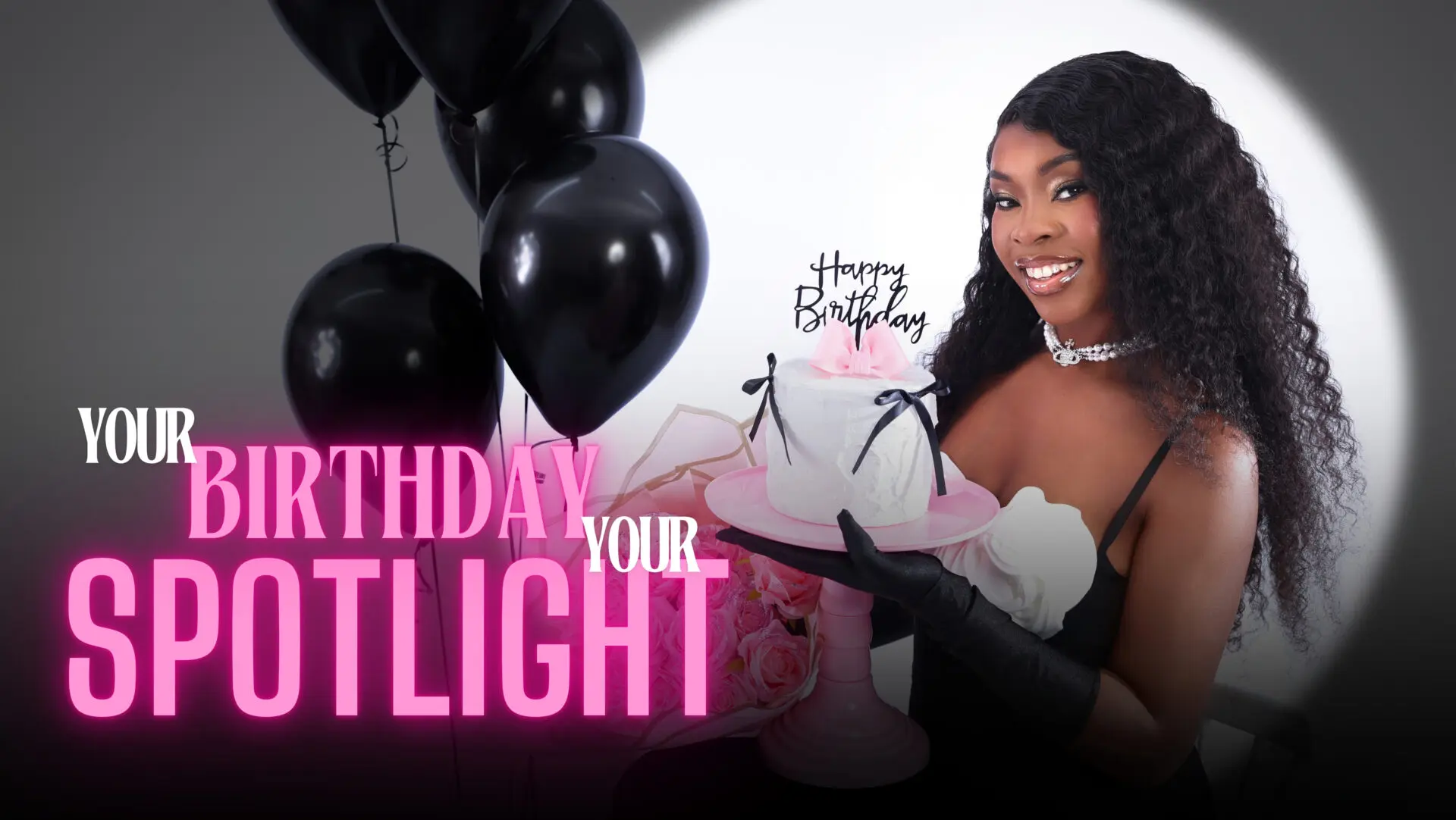 Woman in an elegant dress posing for her birthday photoshoot with stylish decor in the background.