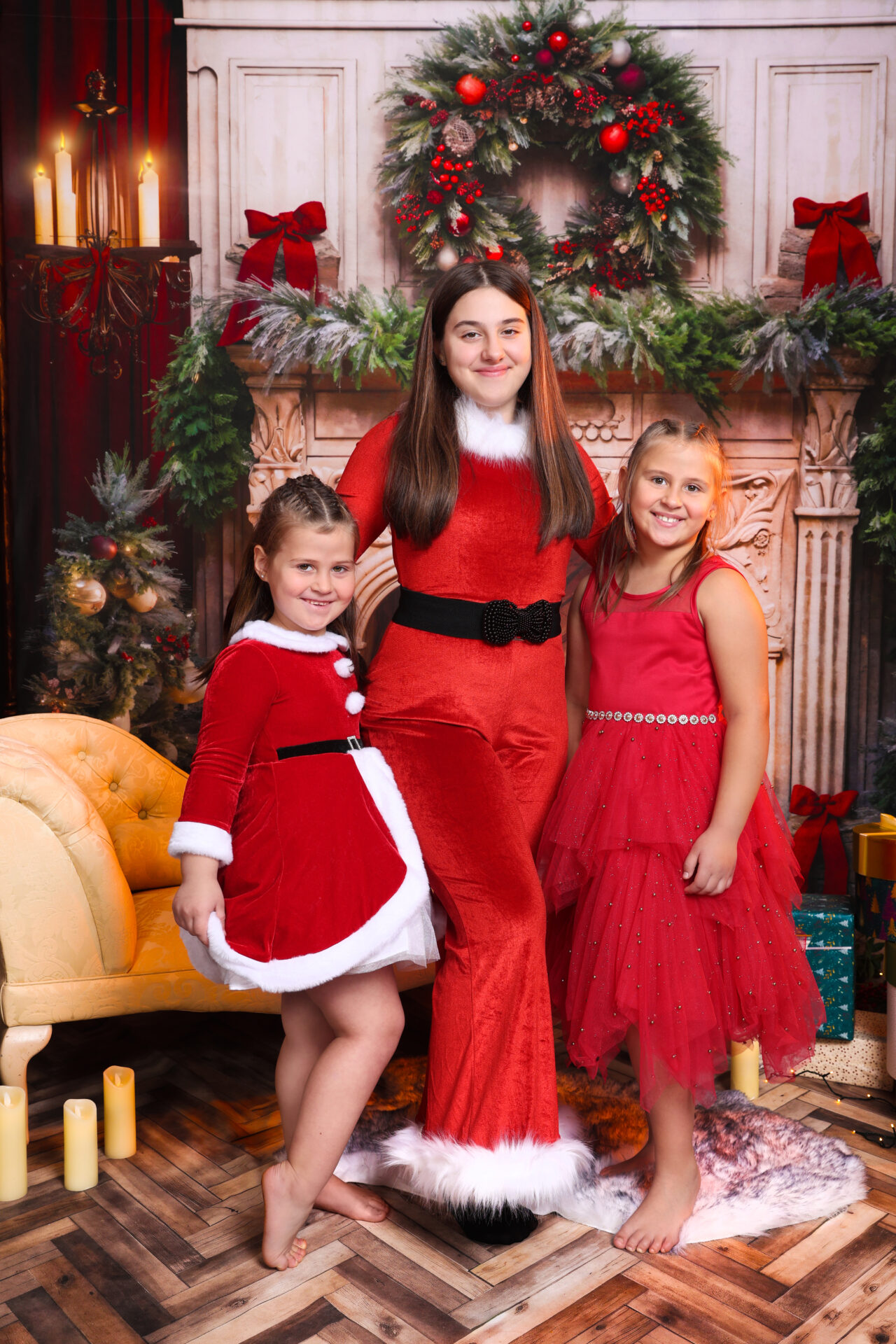 Sisters dressed in red velvet clothes for christmas family photoshoot in studio.