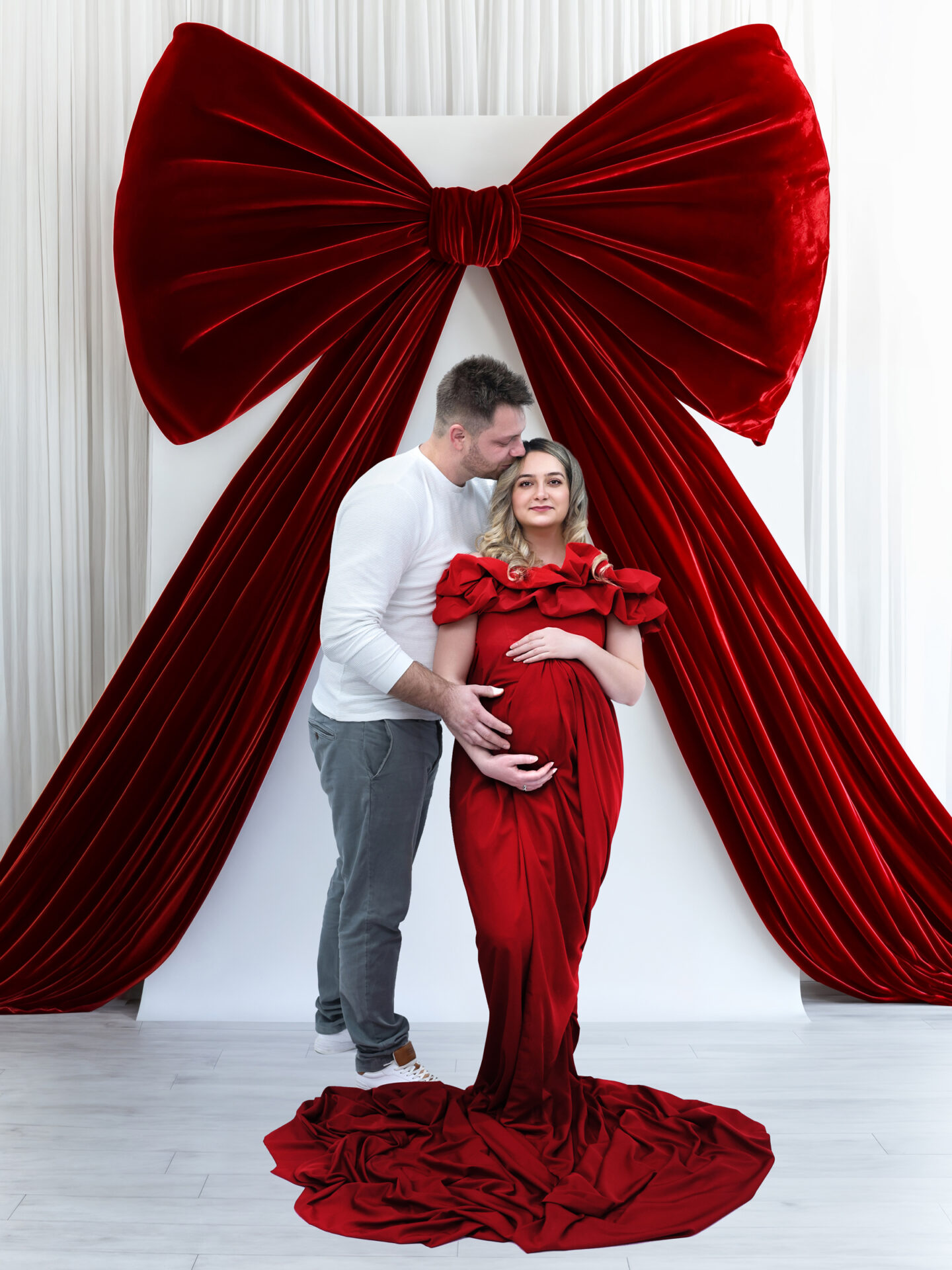 Elegant Maternity Photography in London, red dress and red-bow decor.