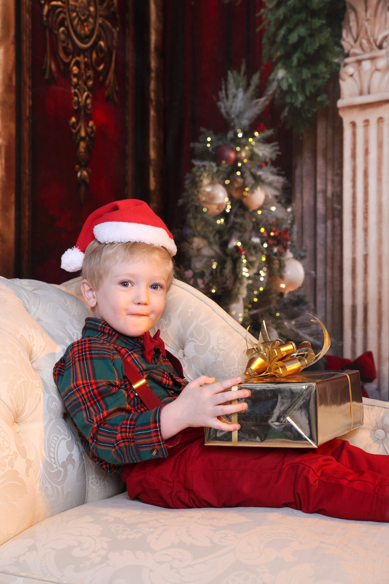 Kid holding a gift box during a photoshoot in studio.