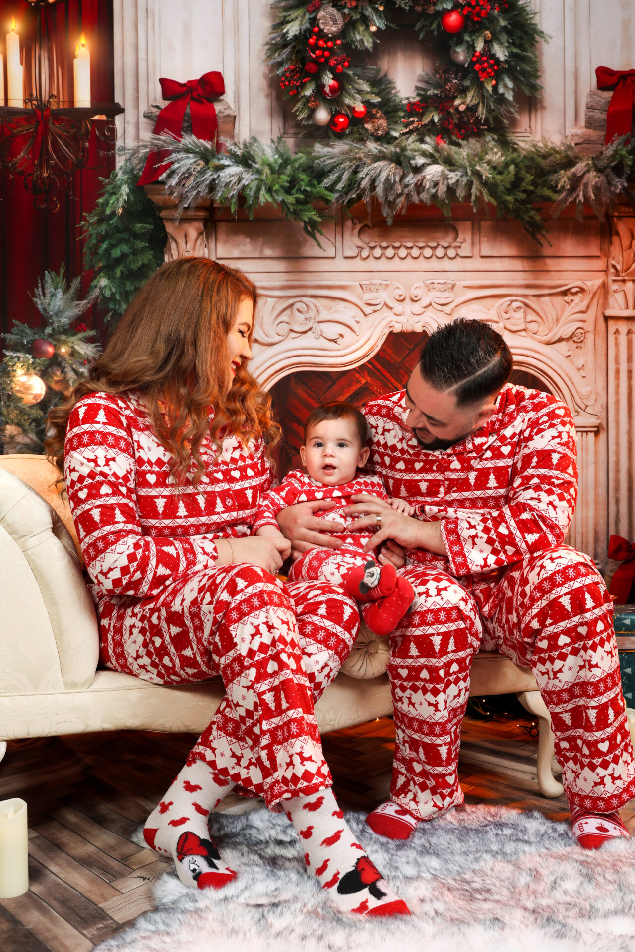 Family sitting on a coach against christmas festive decor during a family festive mini session in London.