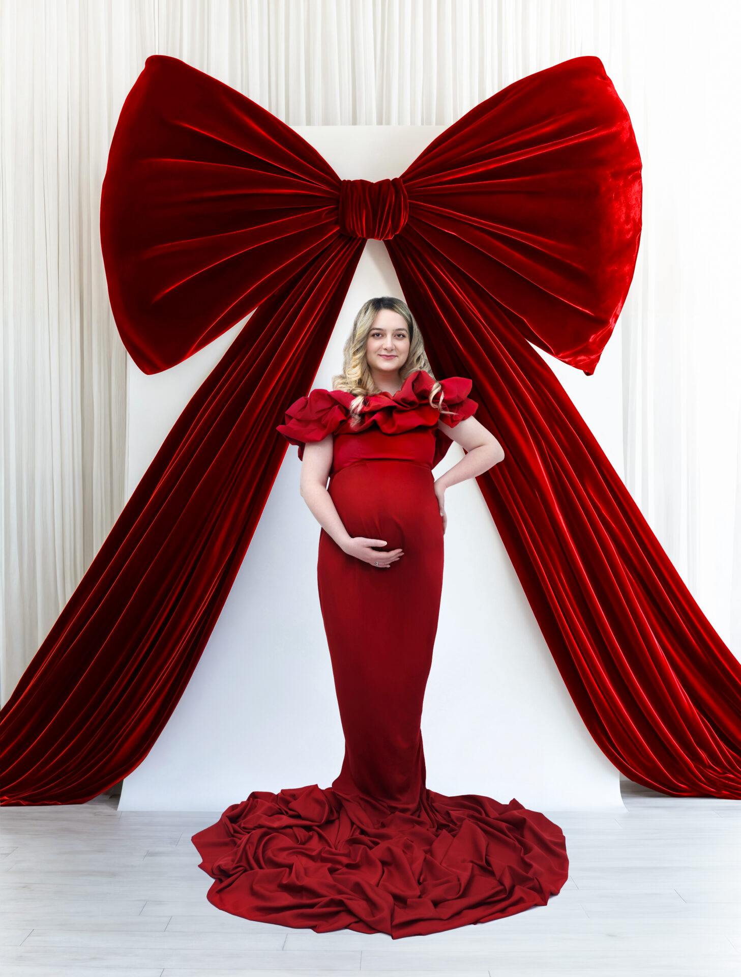 Elegant Maternity Photography in London, red dress and red-bow decor.