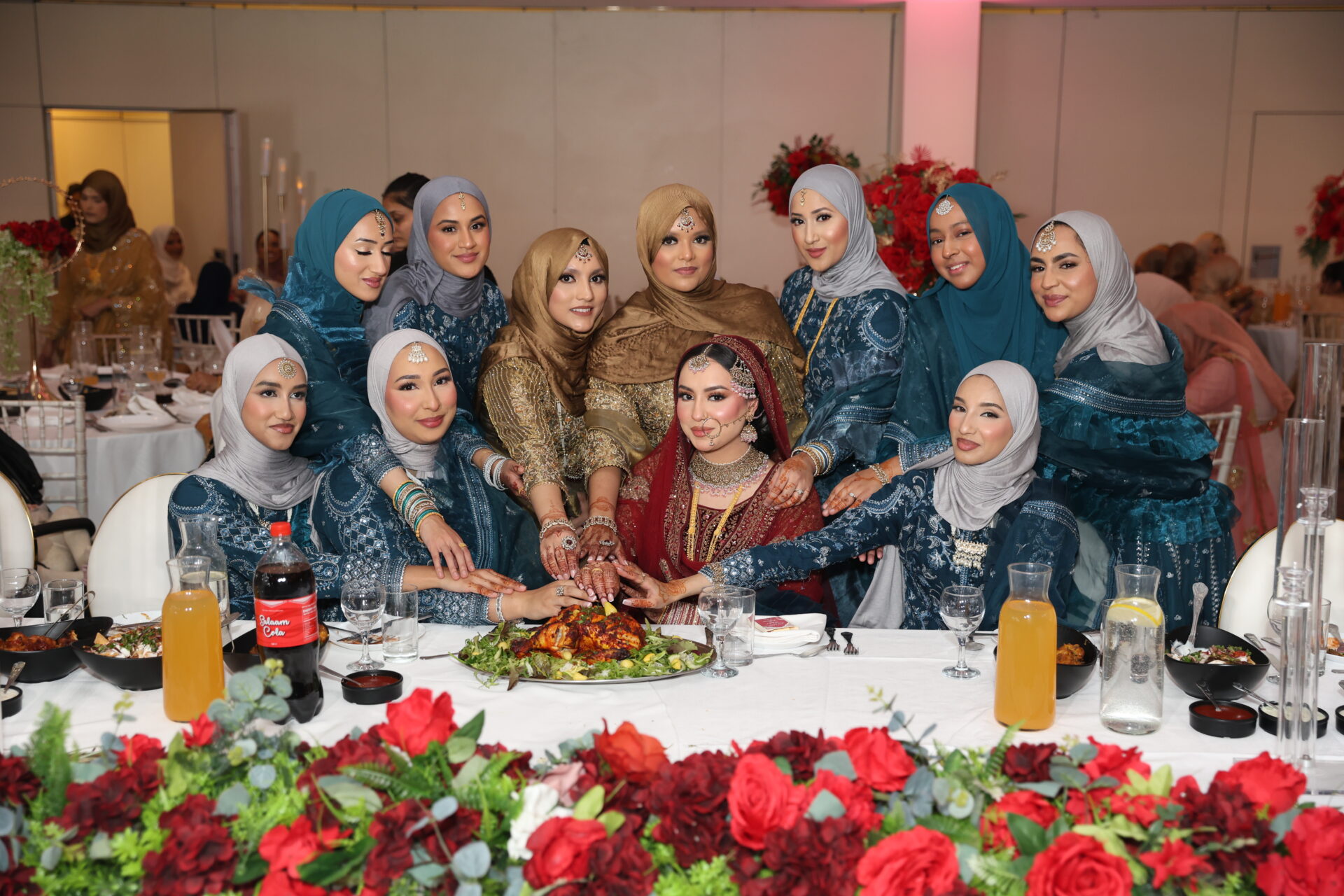 Bride and her bridesmaids sitting on the table for taal during baraat wedding ceremony.