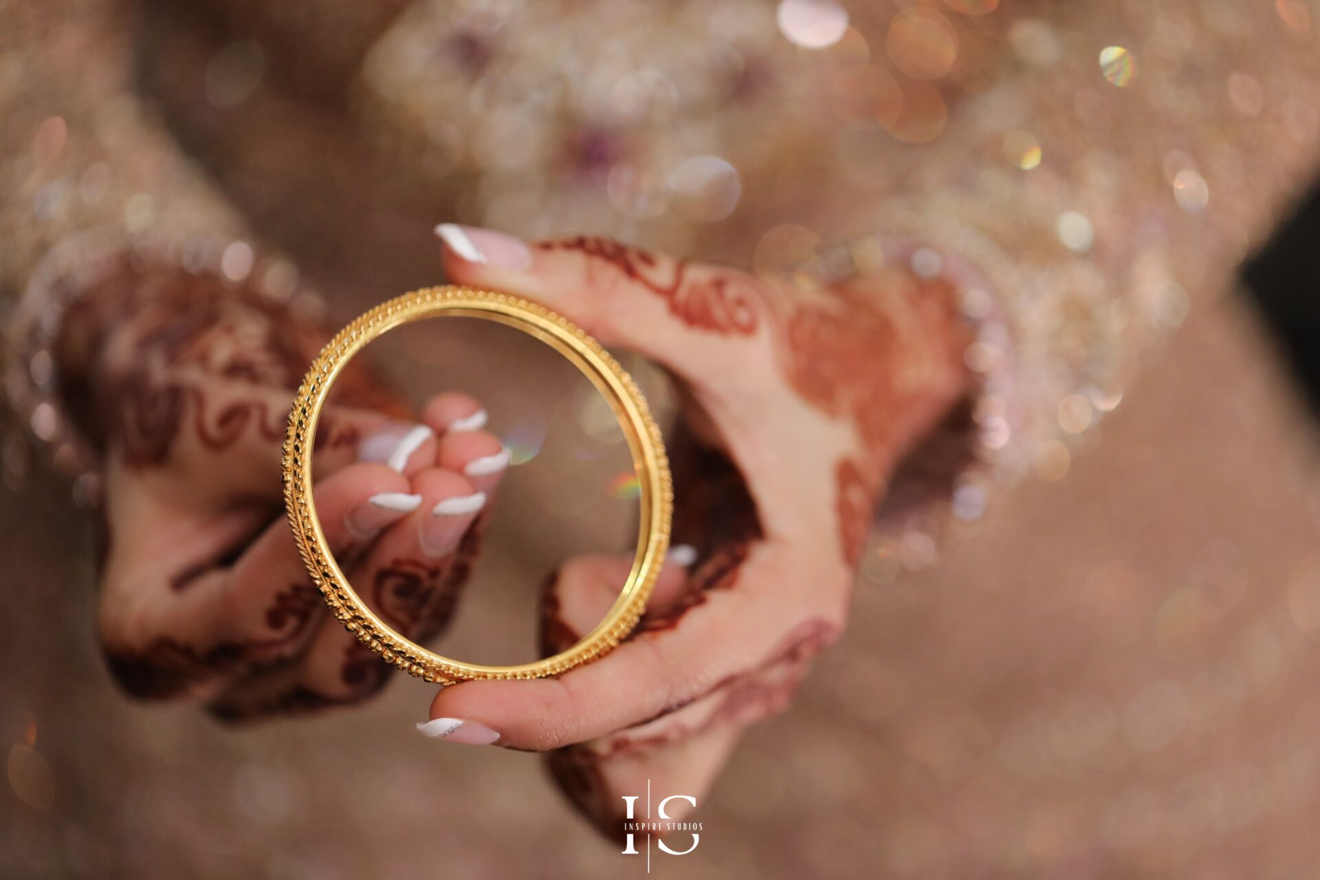 Bride adjusting her traditional golden jewelry during her baraat wedding preparation.