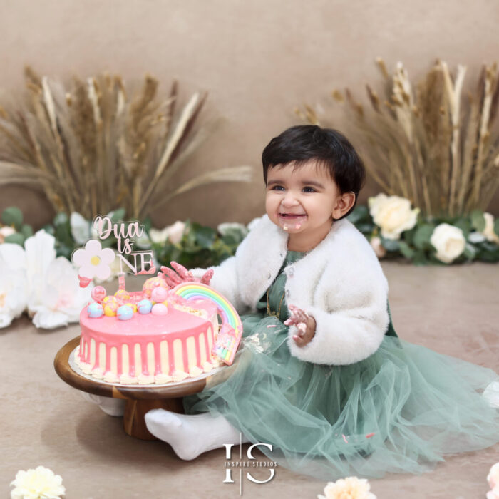 Adorable cake smash session in London with colorful decorations and a smiling baby.