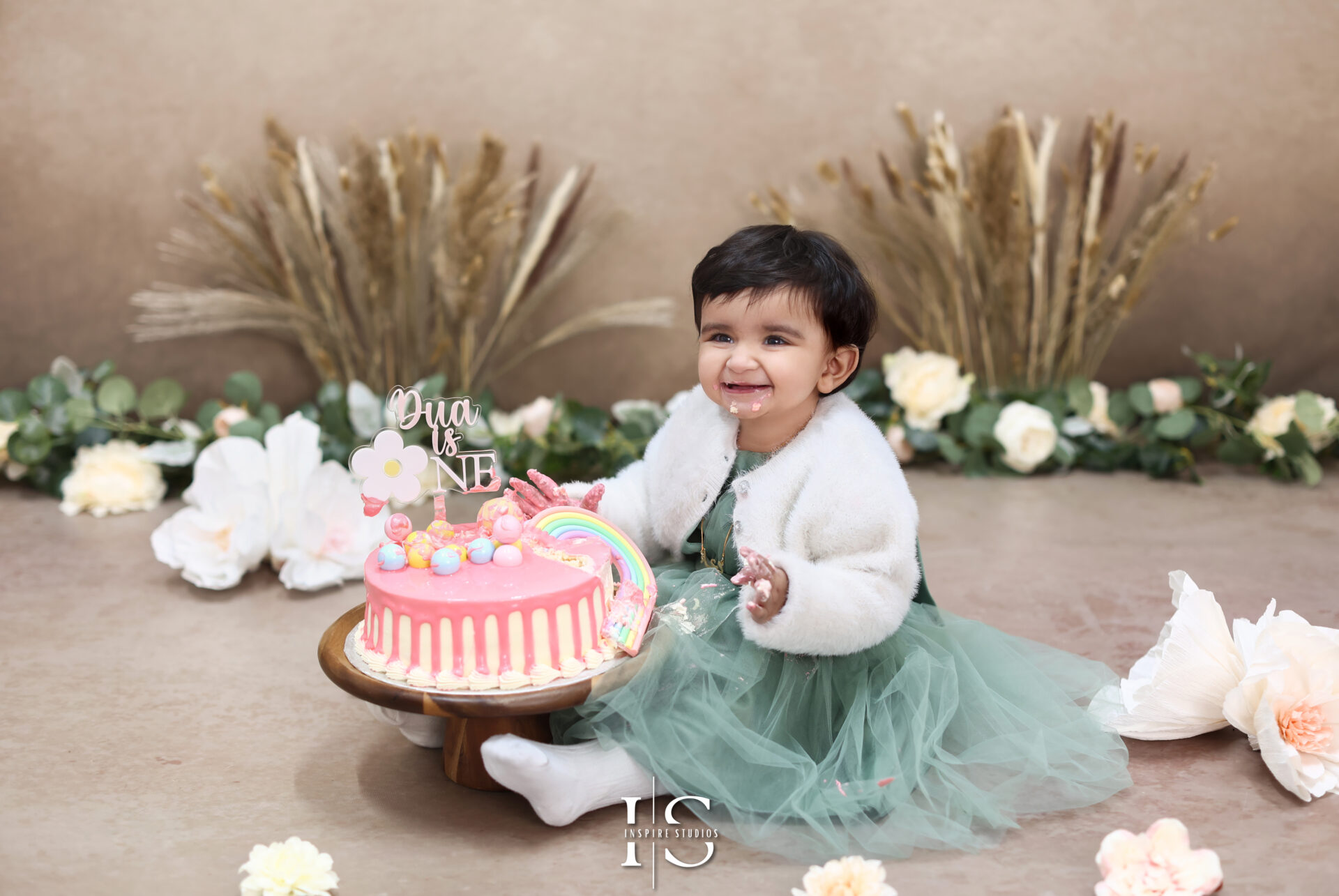 Adorable cake smash session in London with colorful decorations and a smiling baby.