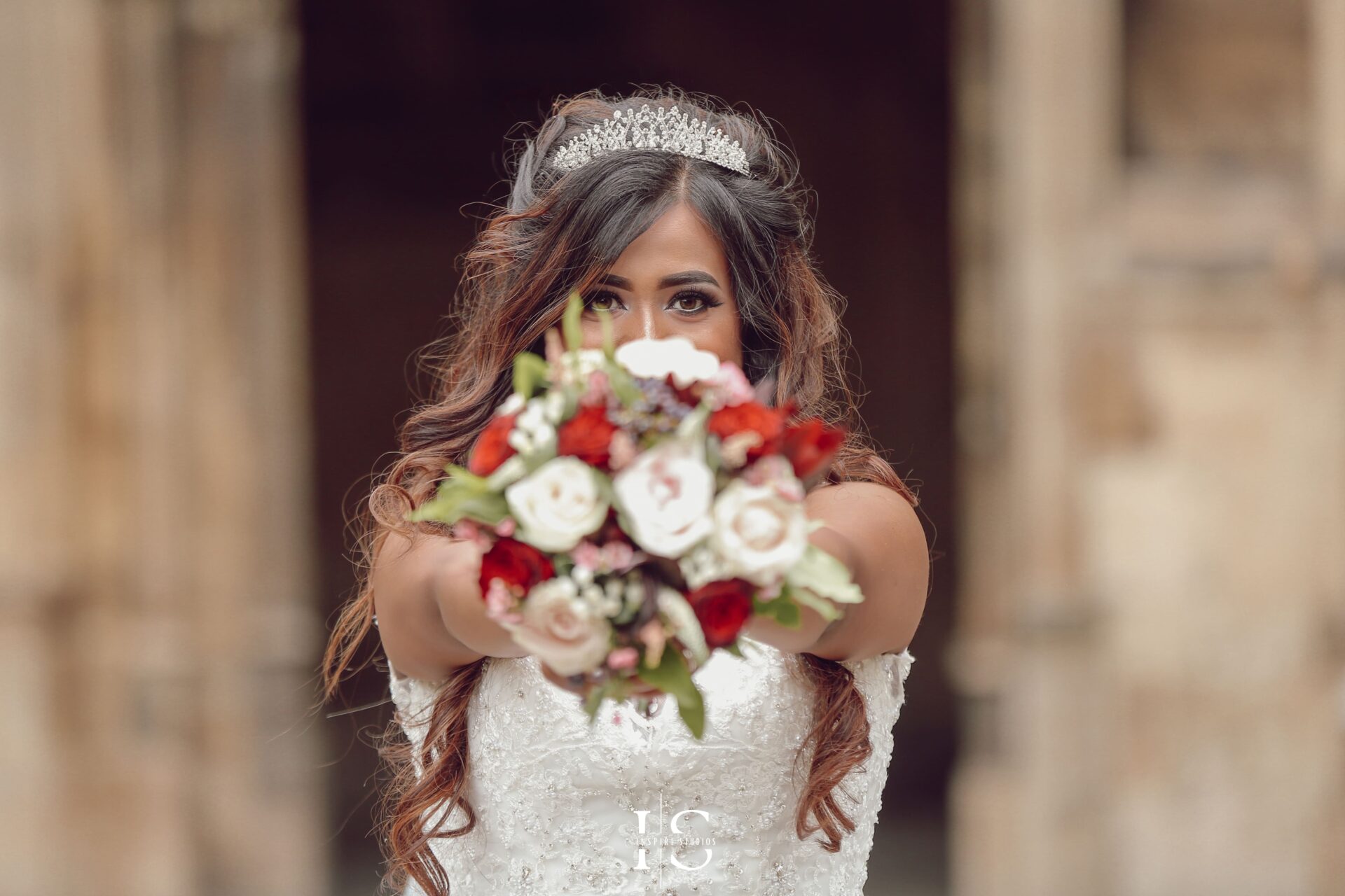 Bride in white dress holding a beautifully decorated bouquet during her wedding photography at church in London.