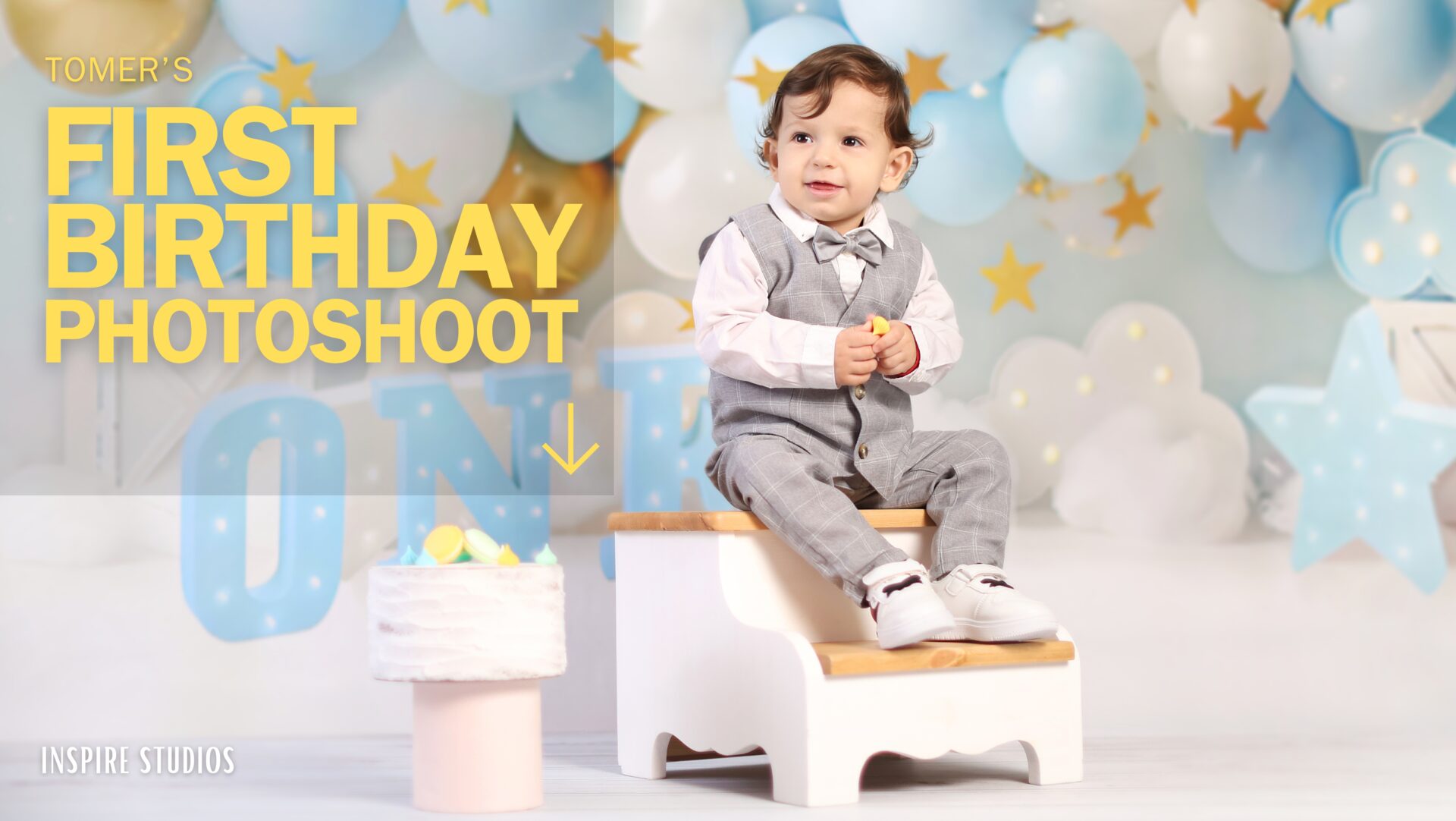 Toddler sitting in a cloud-themed first birthday photoshoot setup with ONE and star decorations.