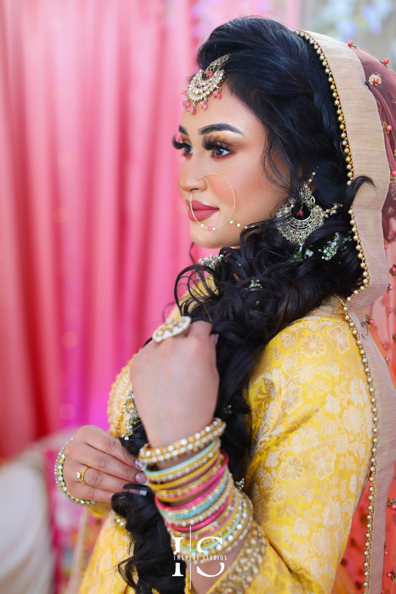 Bride posing with friends and family during her Mehndi wedding photography celebration.