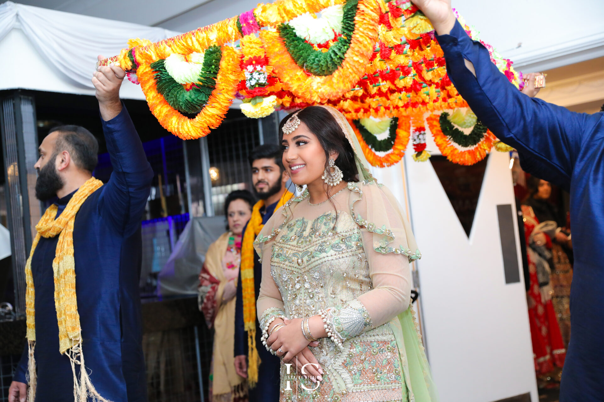 Bride posing with friends and family during her Mehndi wedding photography celebration.