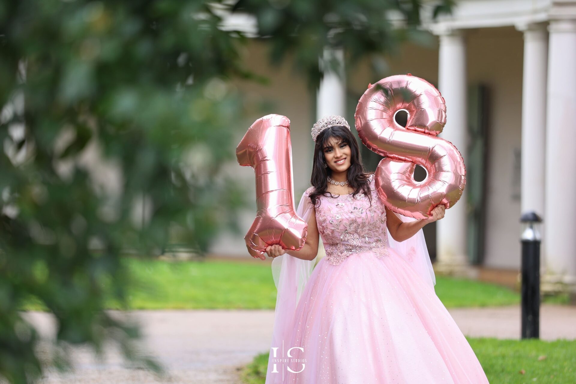 Outdoor birthday photoshoot with 18th balloons number.