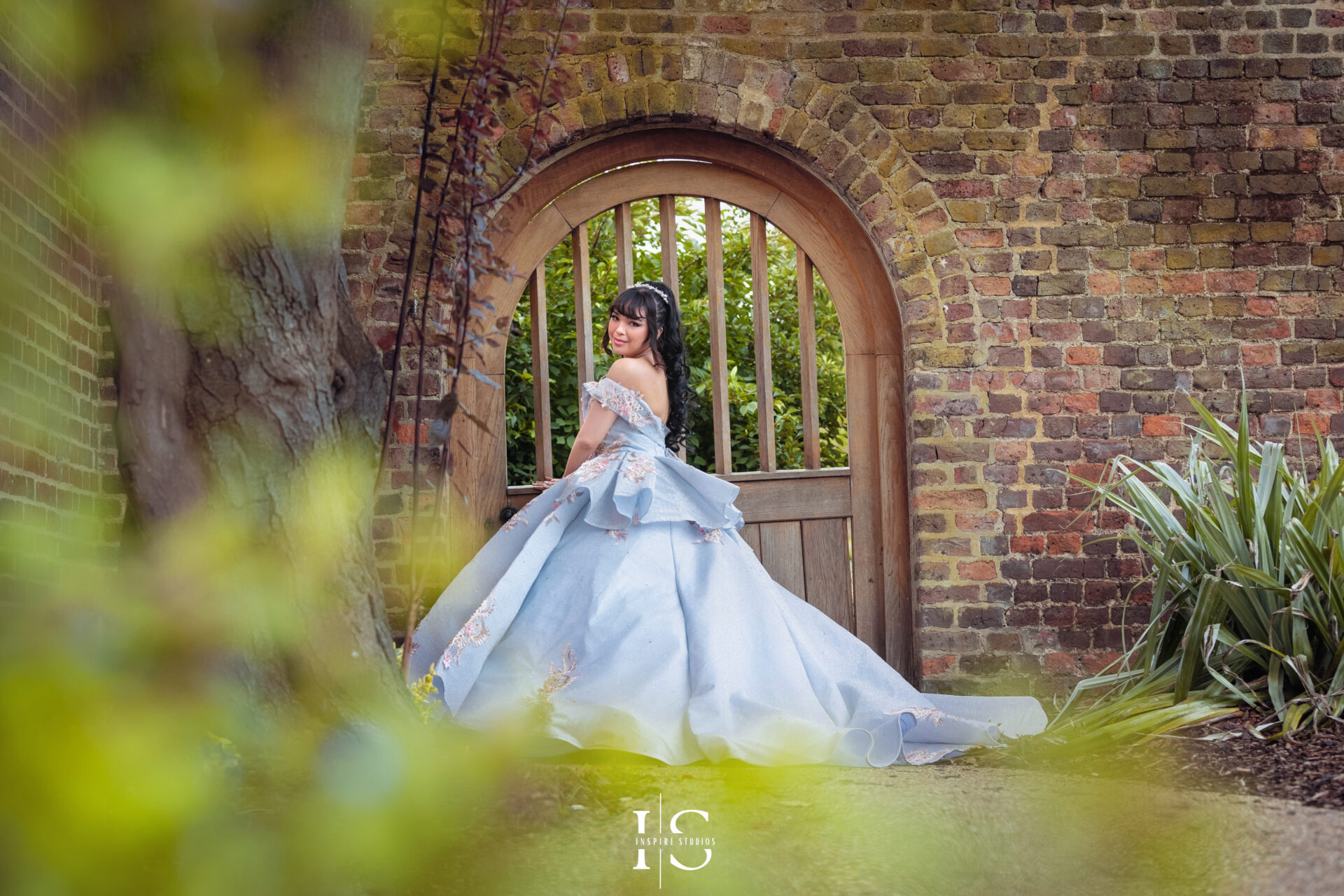 A professional outdoor prom photographer in London captures a young woman in a stunning dress in Valentines Park.