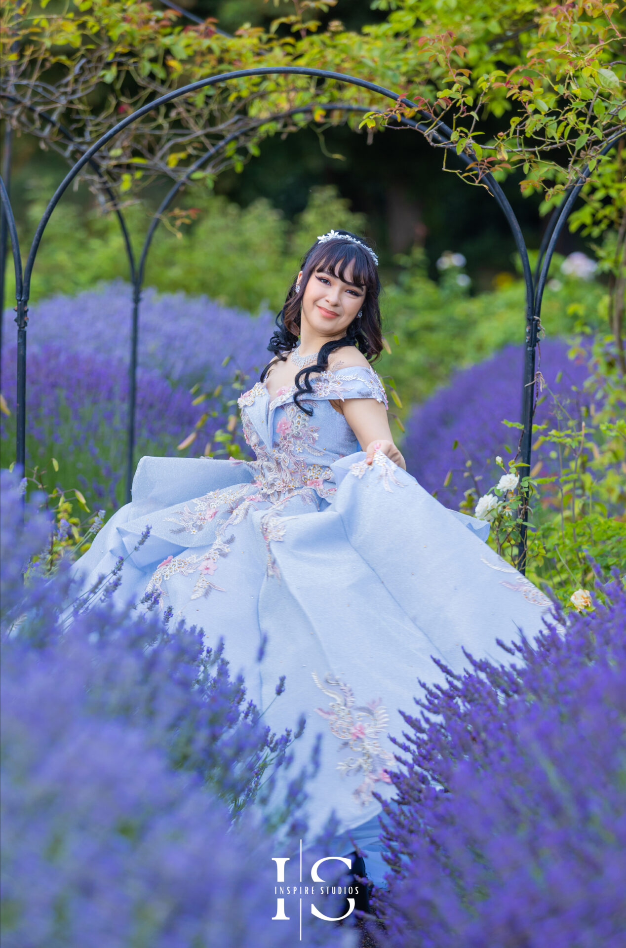 A beautiful outdoor prom photoshoot in Valentines Park, East London, showcasing a young woman posing gracefully in a lavender garden.