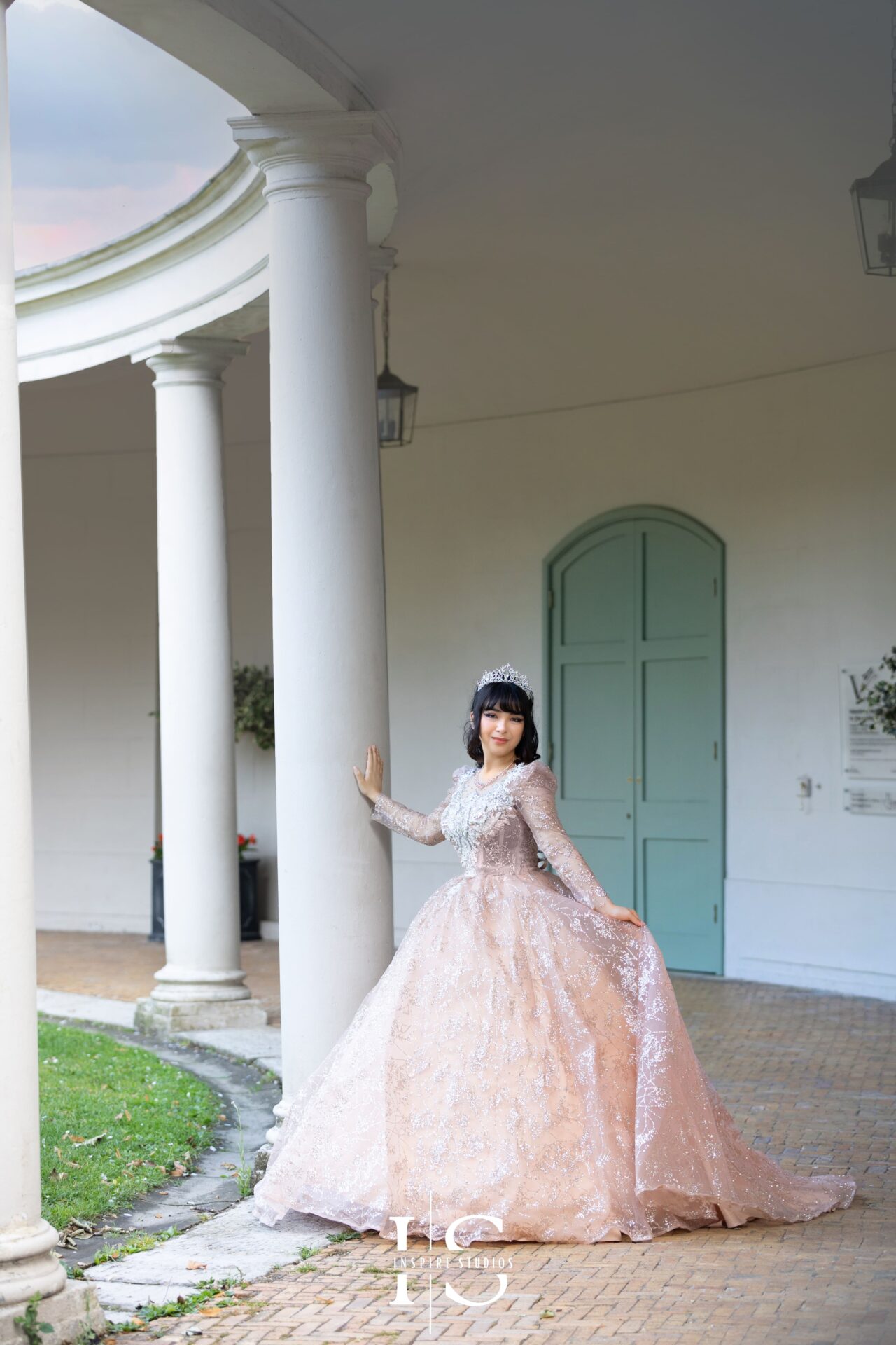 Young woman in a stunning creamy dress posing elegantly outdoors during a prom outdoor photoshoot.