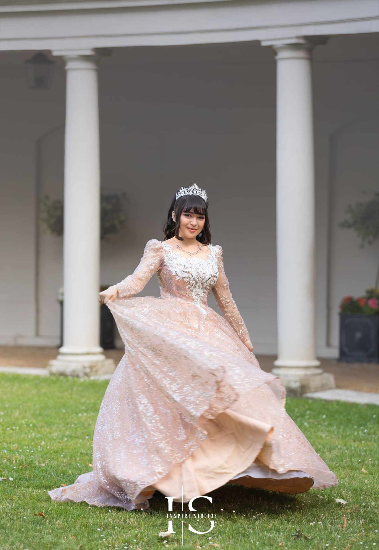 Young woman in a stunning creamy dress posing elegantly outdoors during a prom outdoor photoshoot.