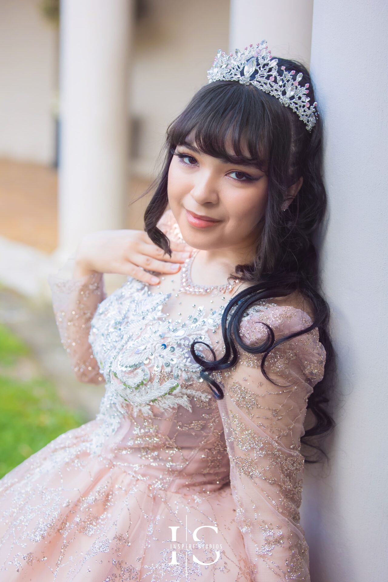 Young woman in a stunning creamy dress posing elegantly outdoors during a prom outdoor photoshoot.