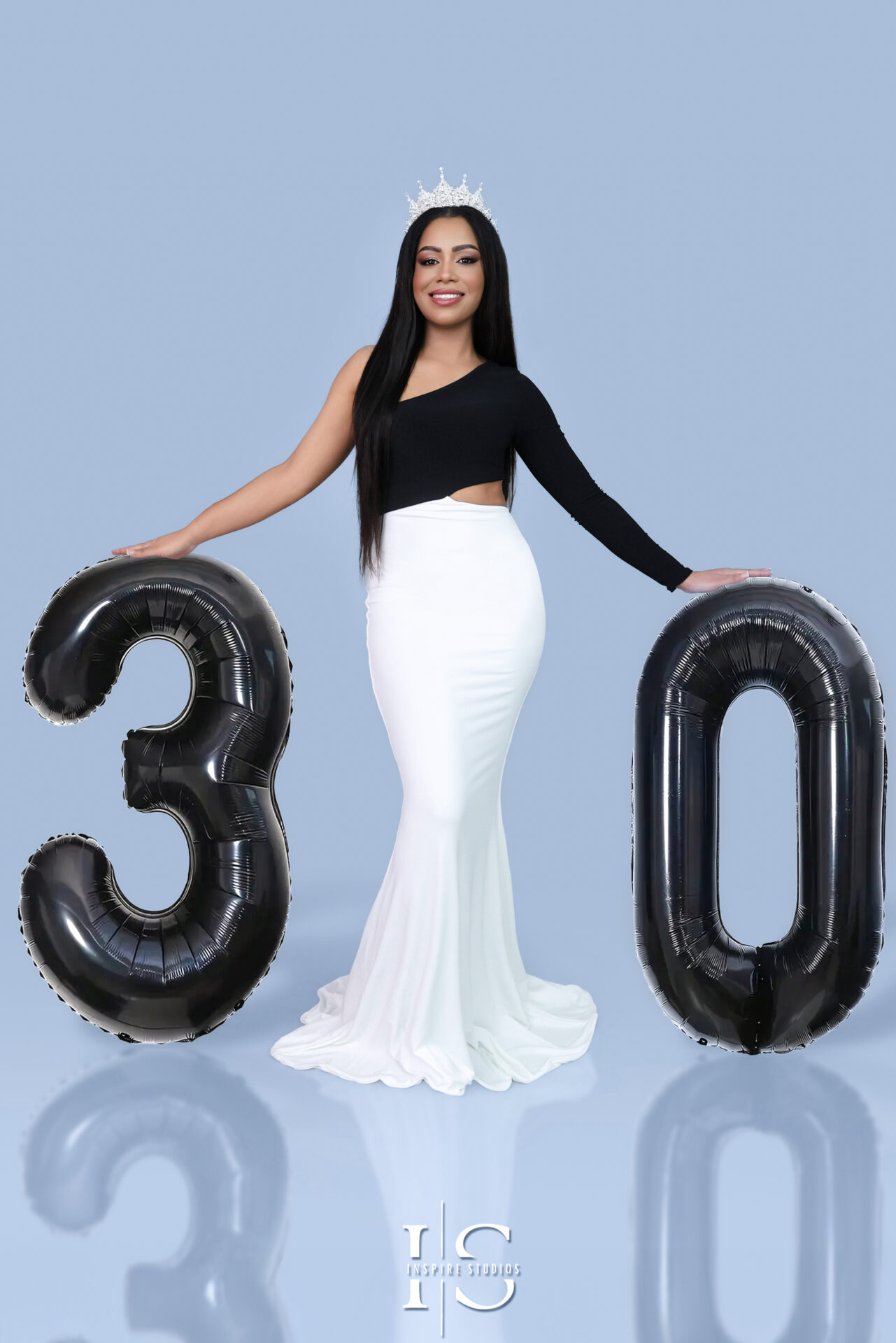 Happy woman posing for 30th anniversary birthday photoshoot in studio.