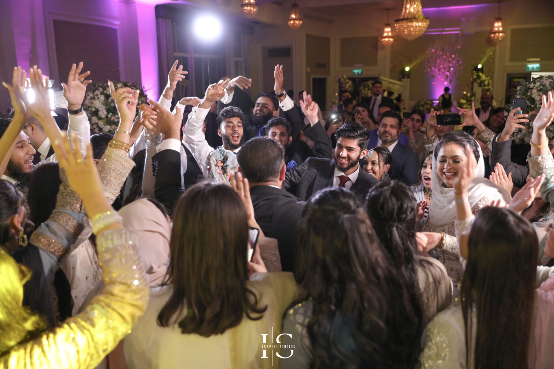 Walima wedding photographer in London capturing groom with family and friends dancing.