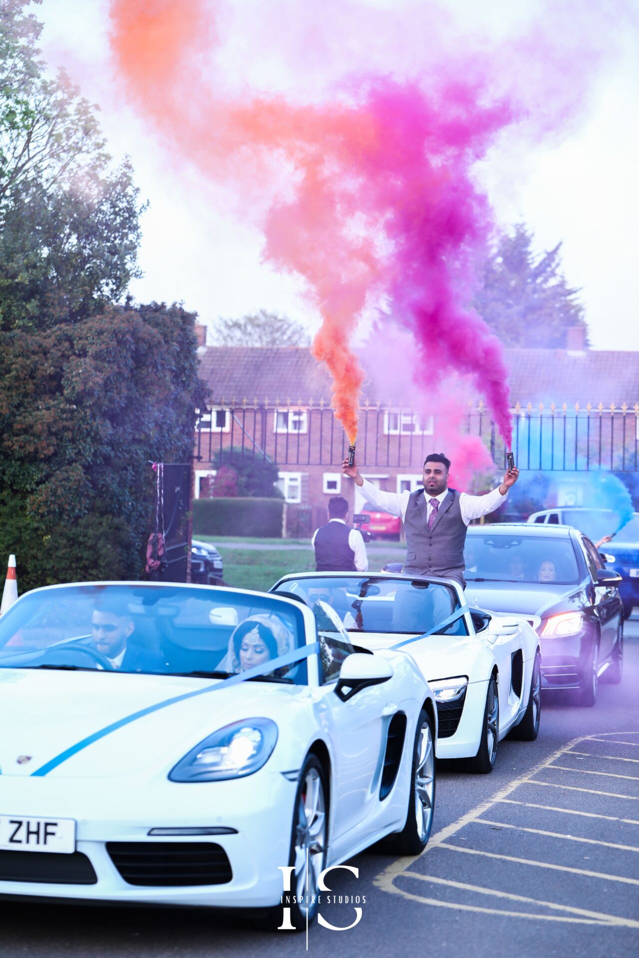 Walima wedding photography london of groom arrival at venue with luxury cars and smoke grenades.