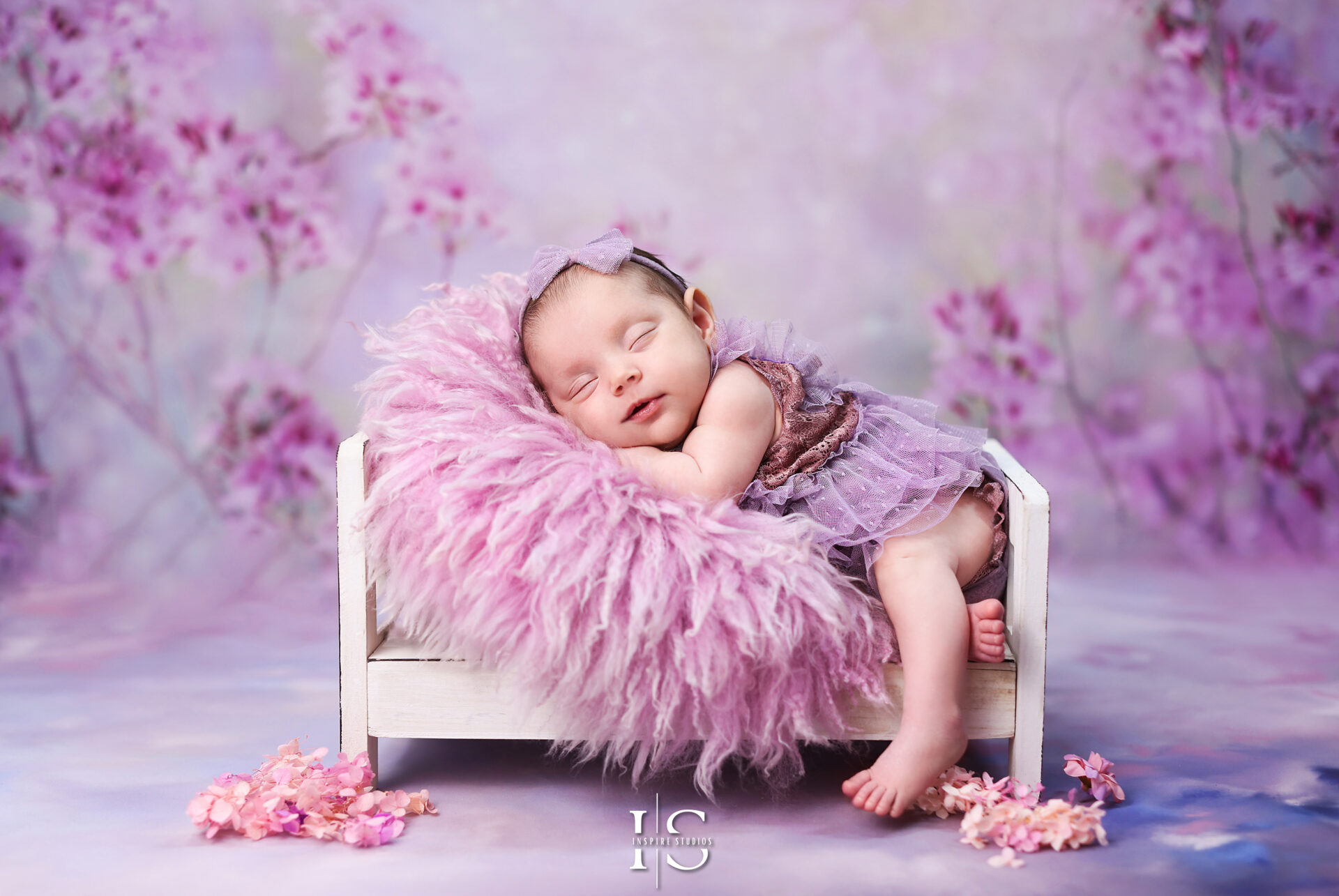 London baby girl newborn photoshoot with cozy blankets and delicate floral themes.