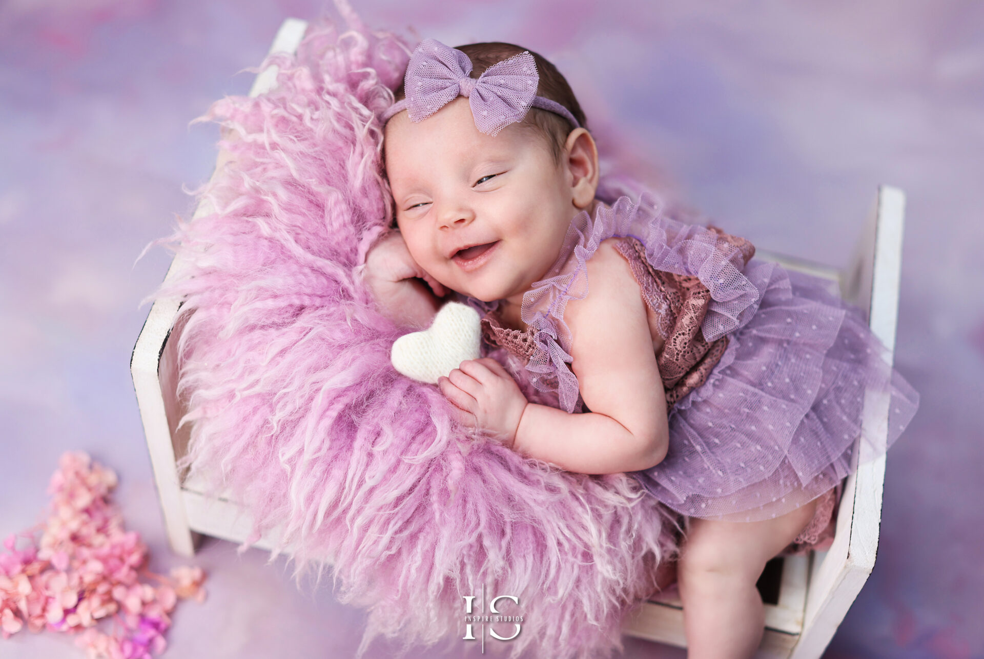 Adorable baby girl newborn photoshoot in London with soft pastel tones and elegant studio setup.