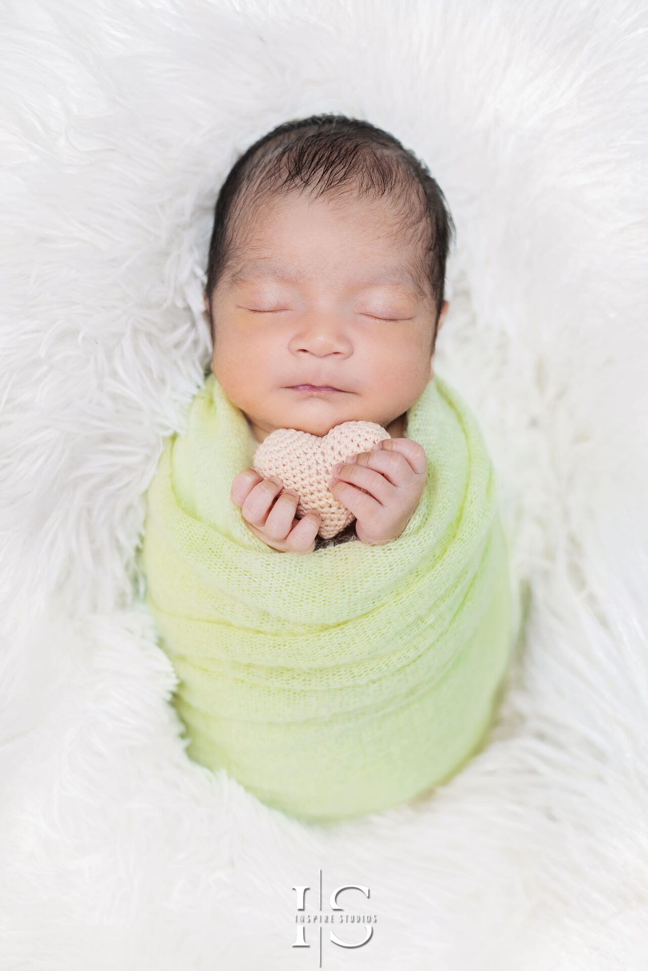 Newborn photoshoot in a cozy London studio with soft lighting and delicate poses.