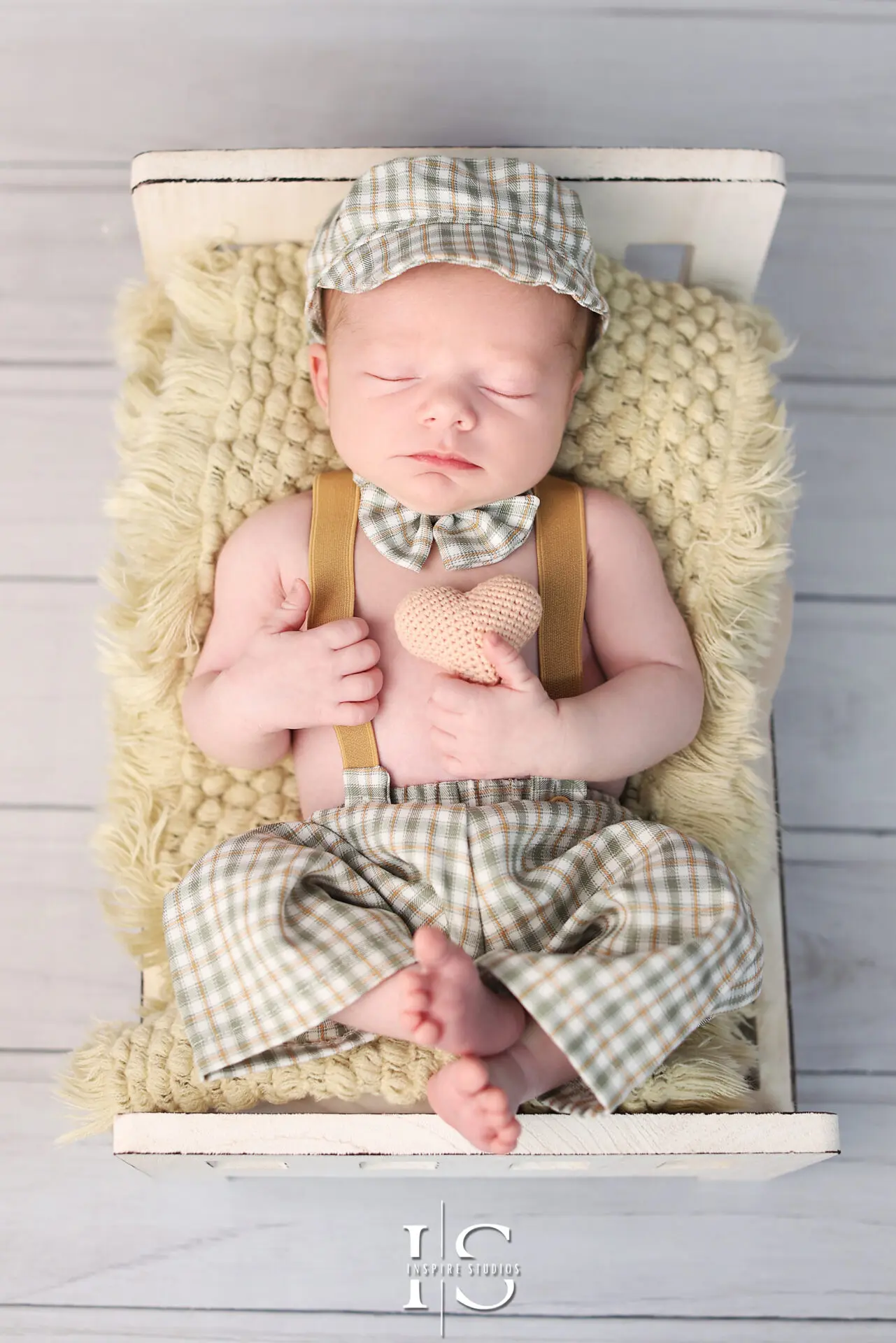 Professional newborn photographer capturing a three-week-old baby in a cozy setup.
