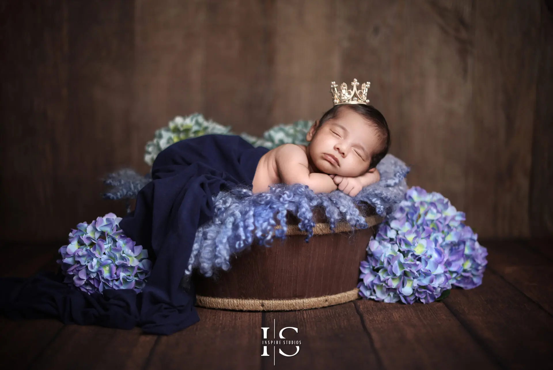 Sleeping newborn baby boy wrapped in a blue blanket.