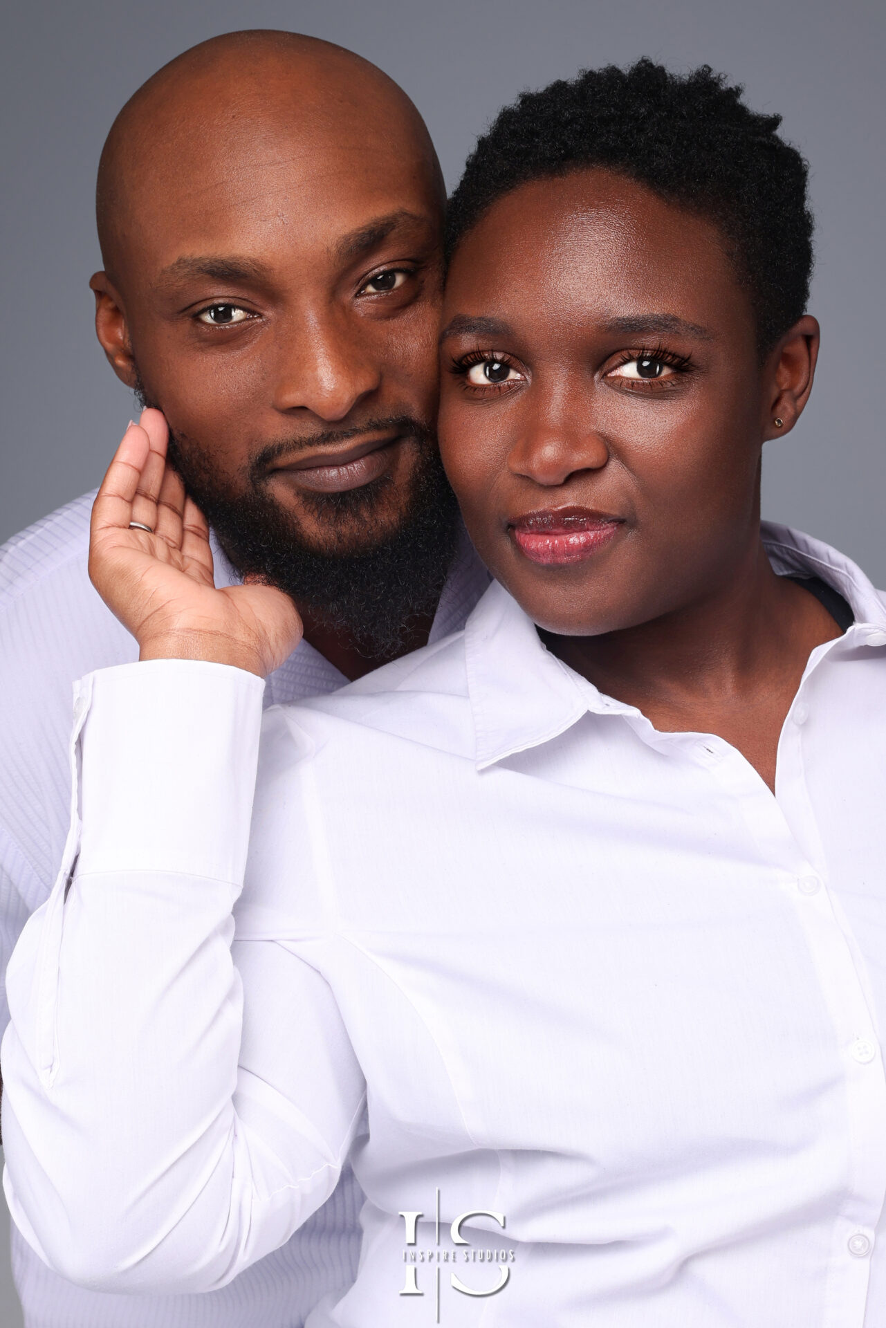 A couple holds hands while gazing into each other’s eyes during a luxury studio photoshoot in London.