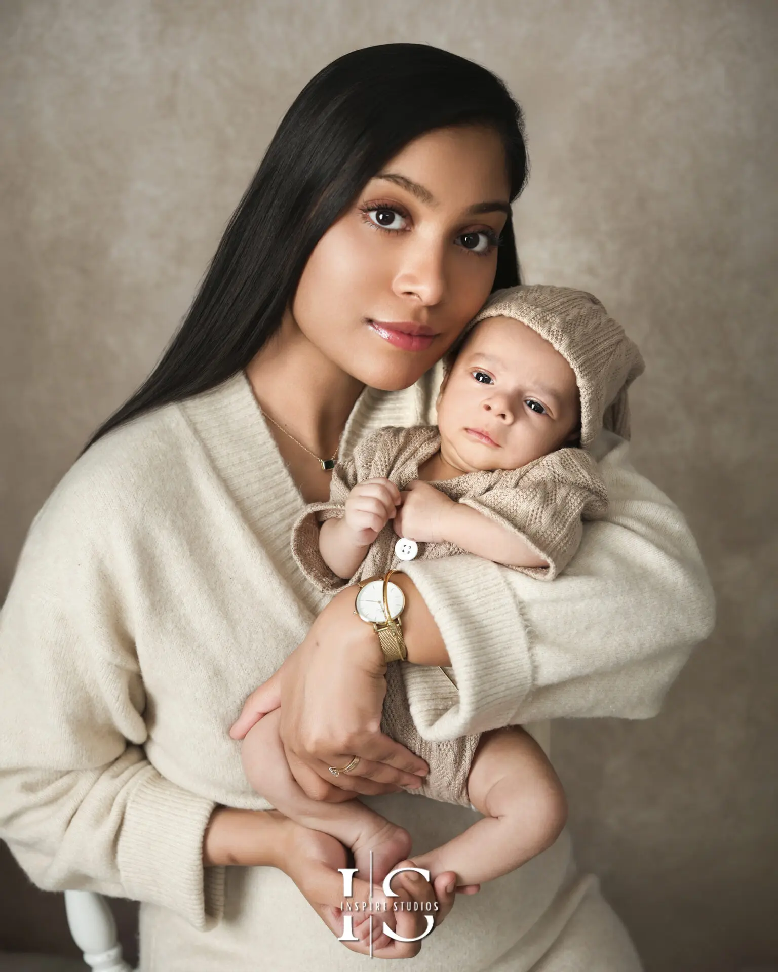 A joyful family cuddling their newborn during a natural outdoor photoshoot in London.