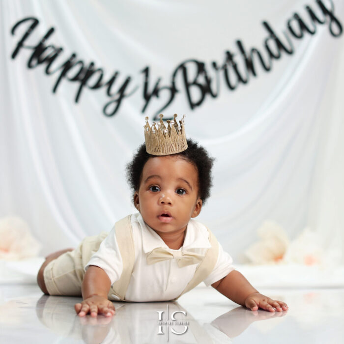 Baby enjoying a fun and colorful half birthday photo session in a studio.
