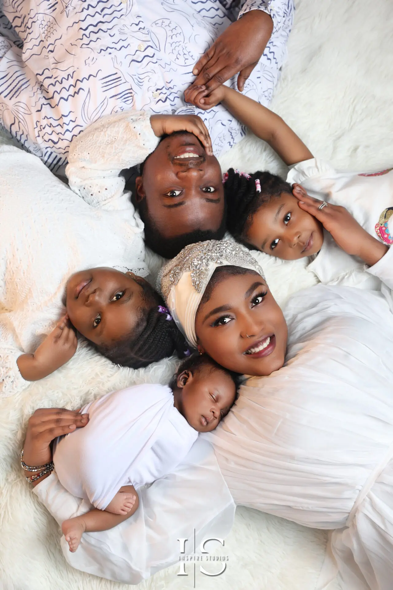 Parents holding their newborn baby in a professional Walthamstow studio photoshoot.