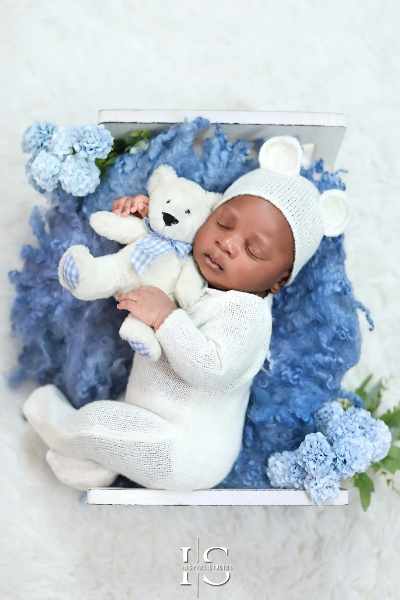One-week-old baby boy peacefully sleeping on a soft blanket.