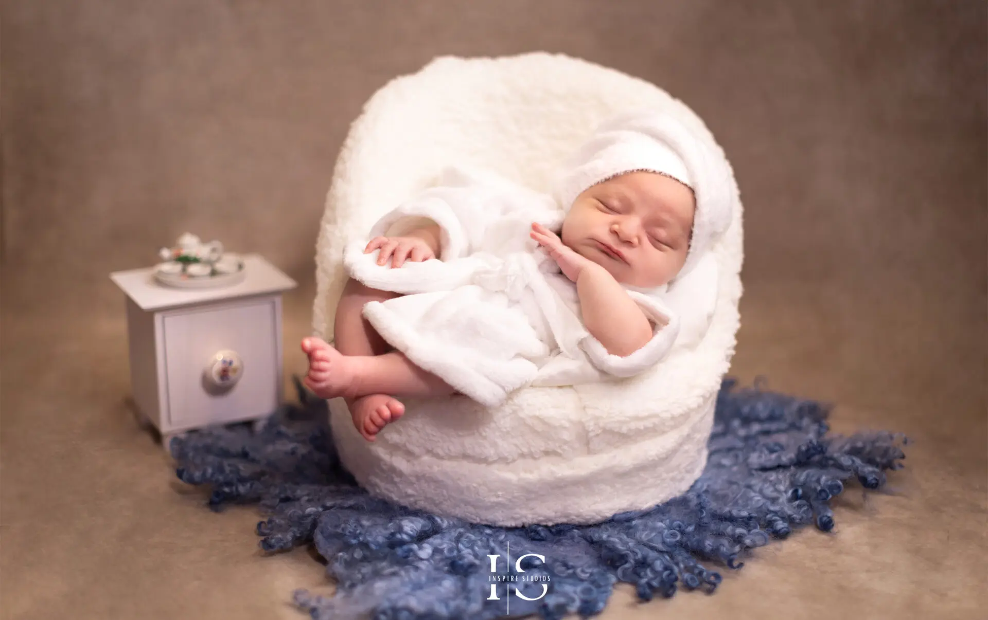 One-week-old baby girl in a floral-themed studio photoshoot.