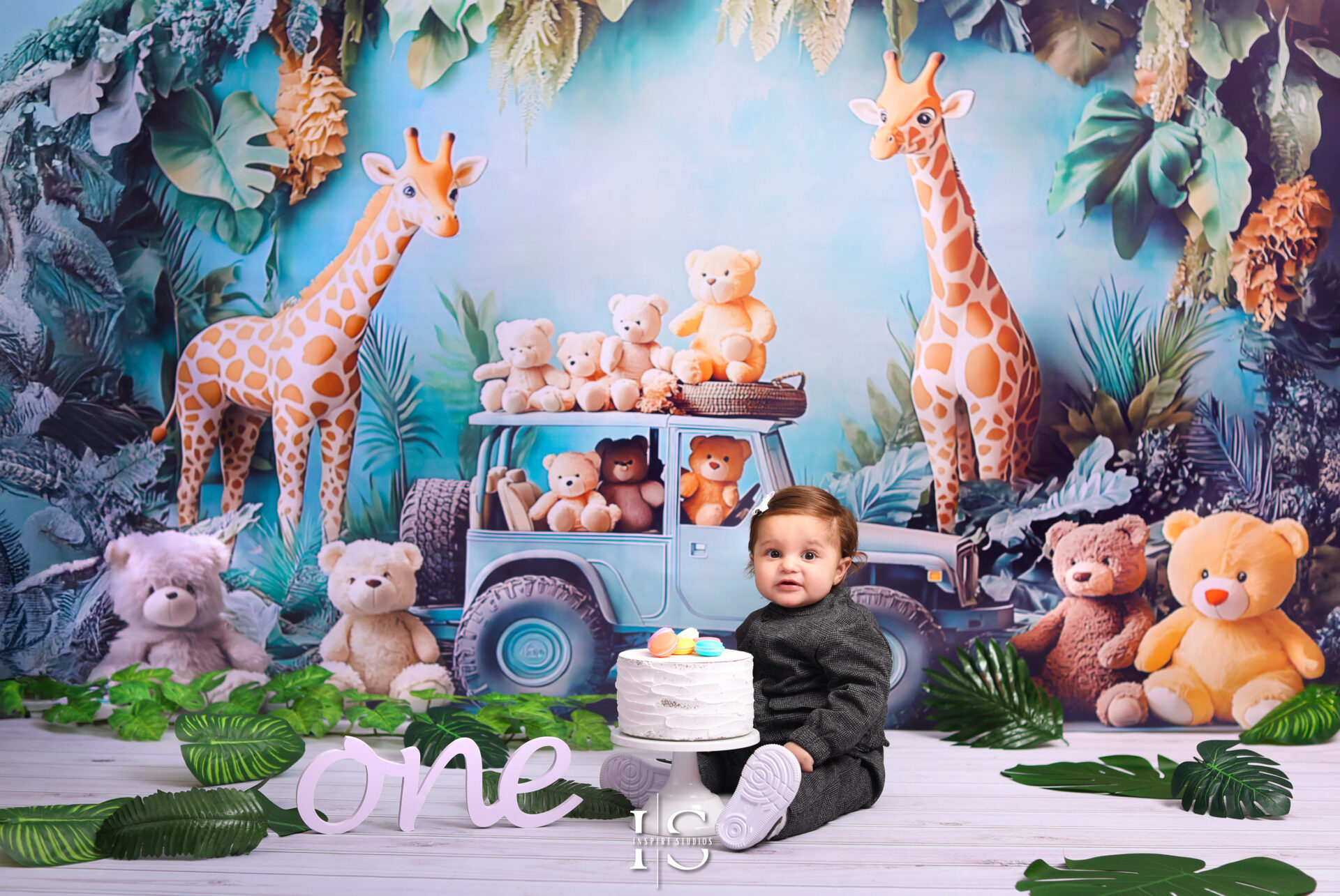 Baby's first birthday photoshoot in London with a "Wild & One" theme, including greenery backdrop and safari-inspired props.