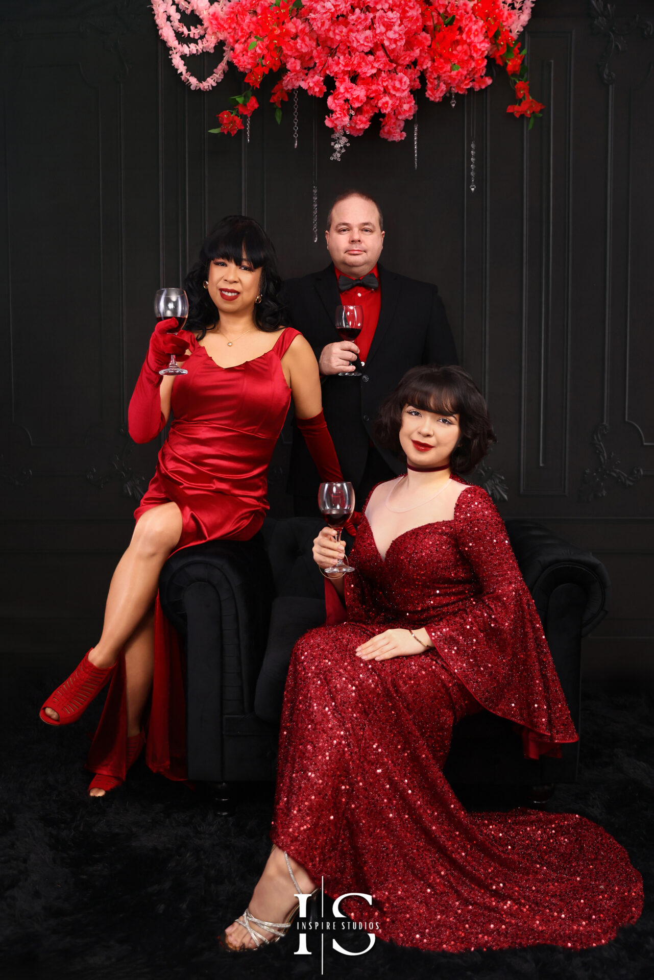 Family wearing black and red outfits during a creative themed photoshoot.