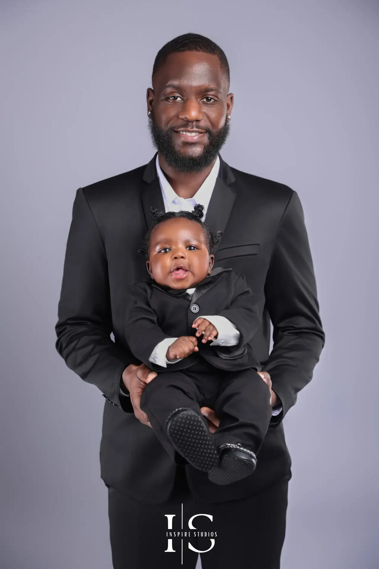 Father holding baby close in a studio portrait