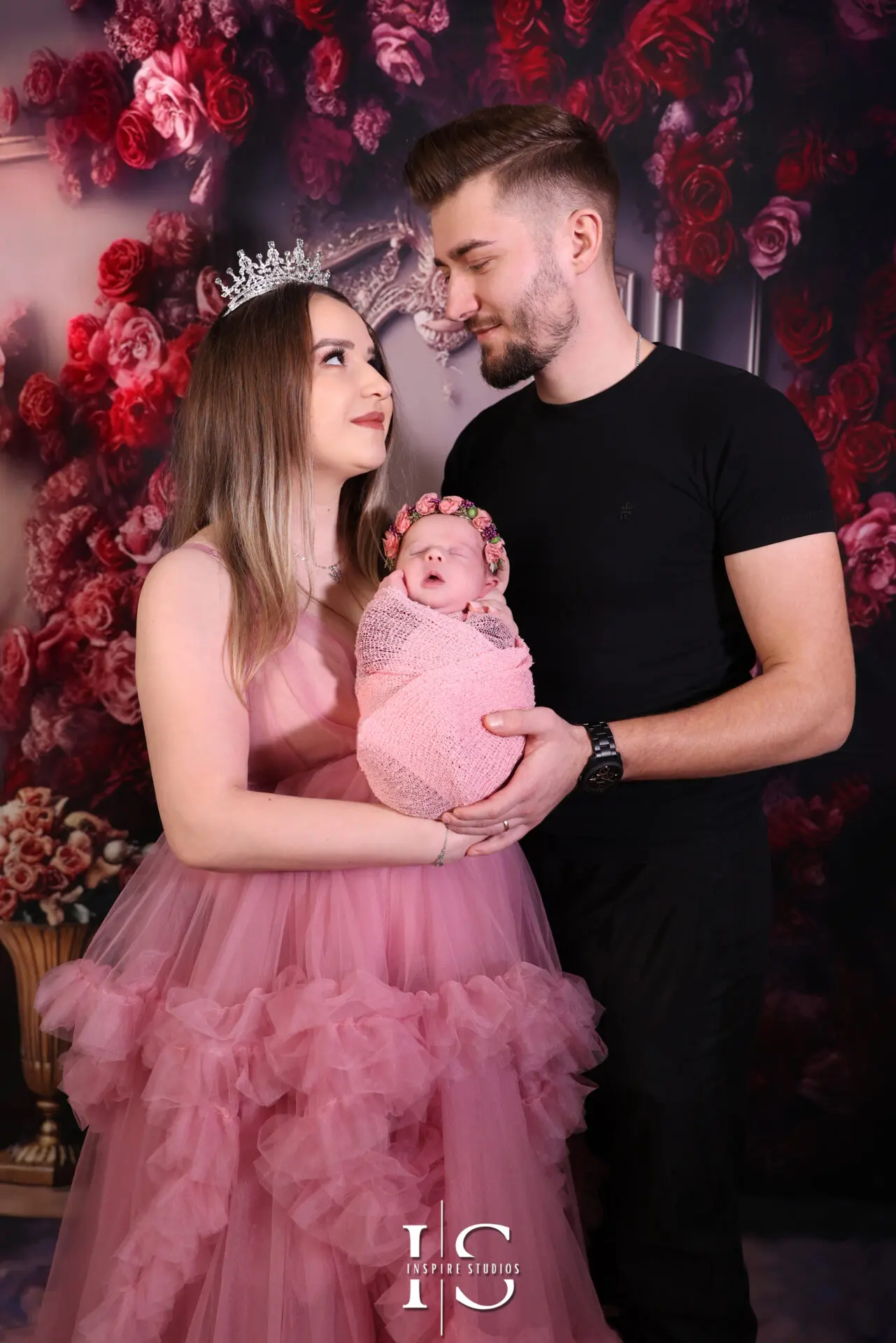 Family gathered around newborn during a professional studio photo session.
