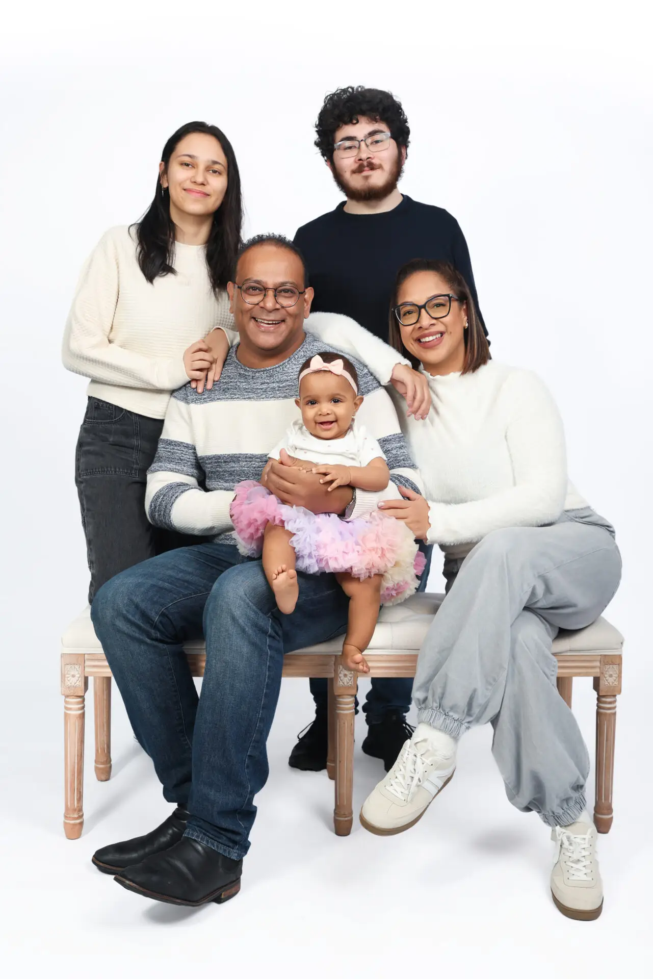 Family group photo in a London studio with simple, classic backdrop.