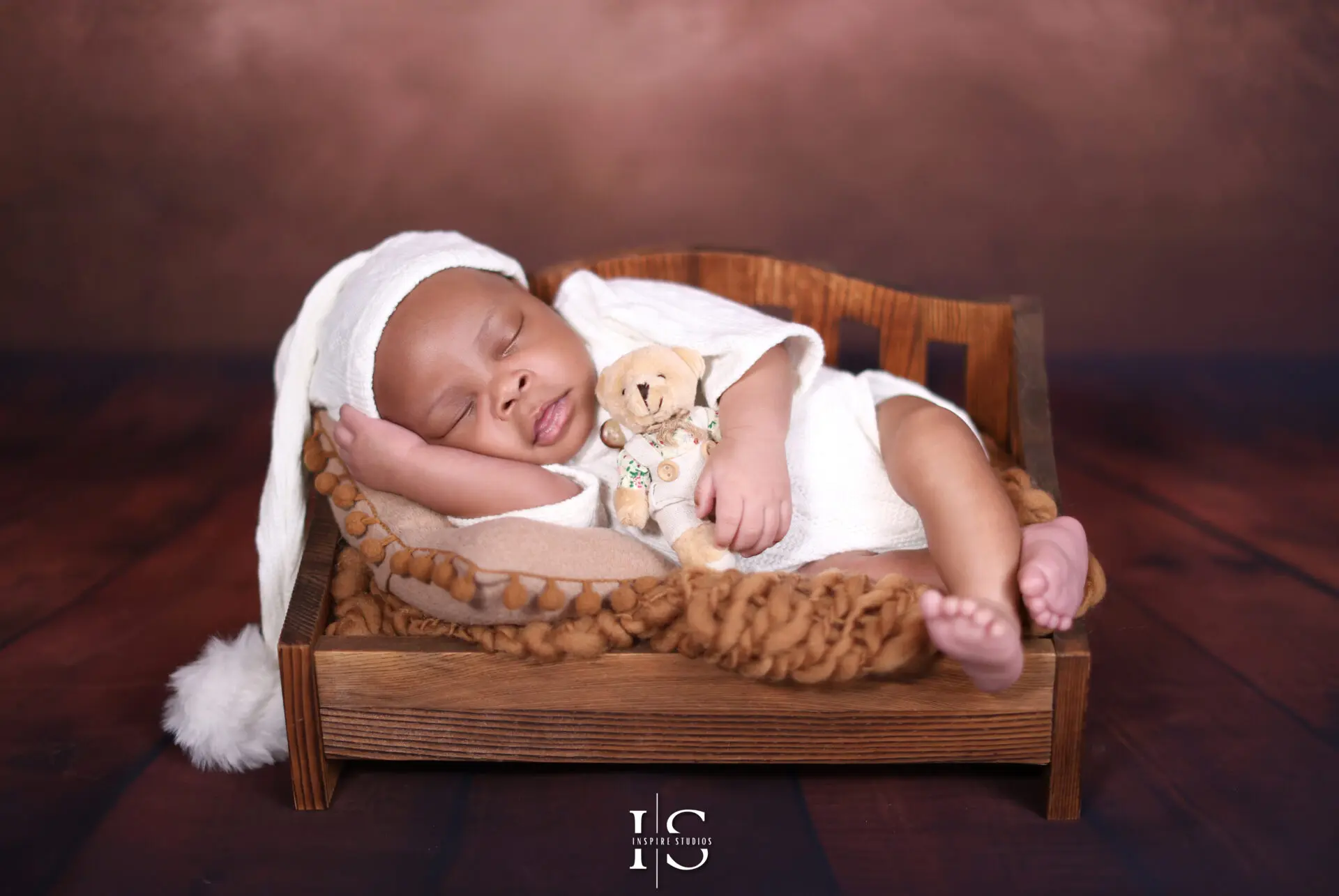Experienced female newborn photographer in London capturing a baby girl in a soft pink wrap.