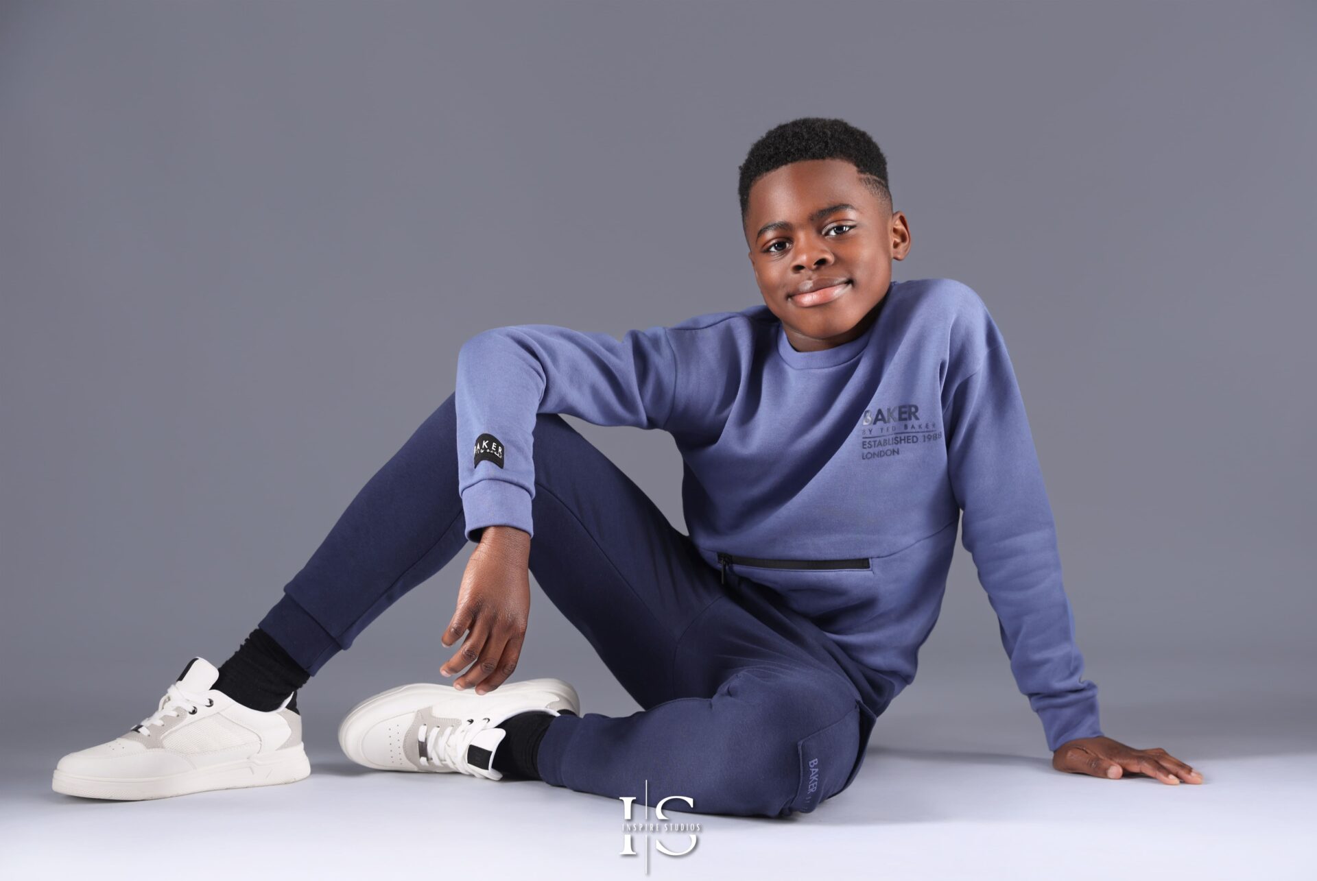 Smiling 10-year-old boy posing confidently in a professional studio photoshoot.