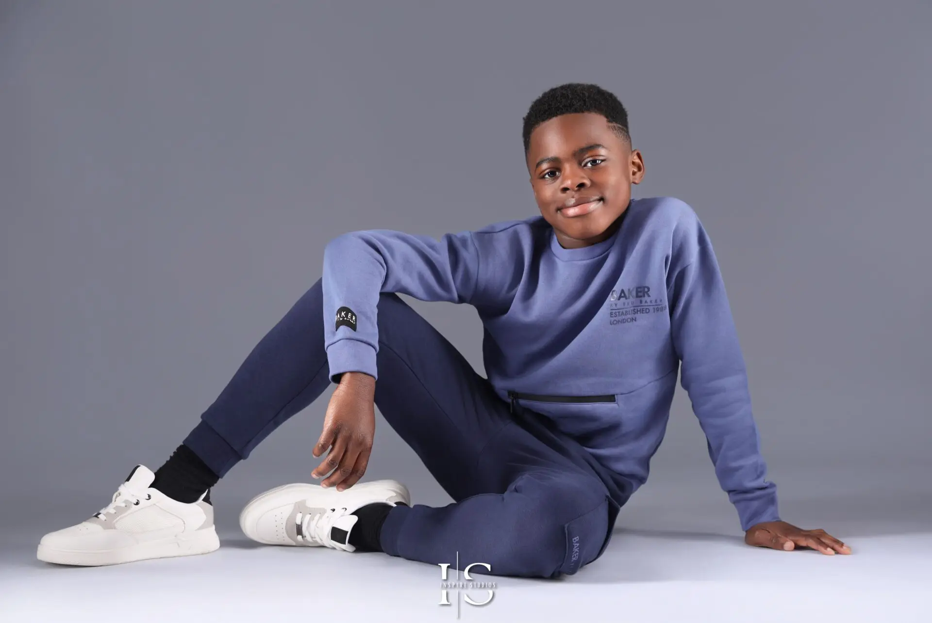 Smiling 10-year-old boy posing confidently in a professional studio photoshoot.